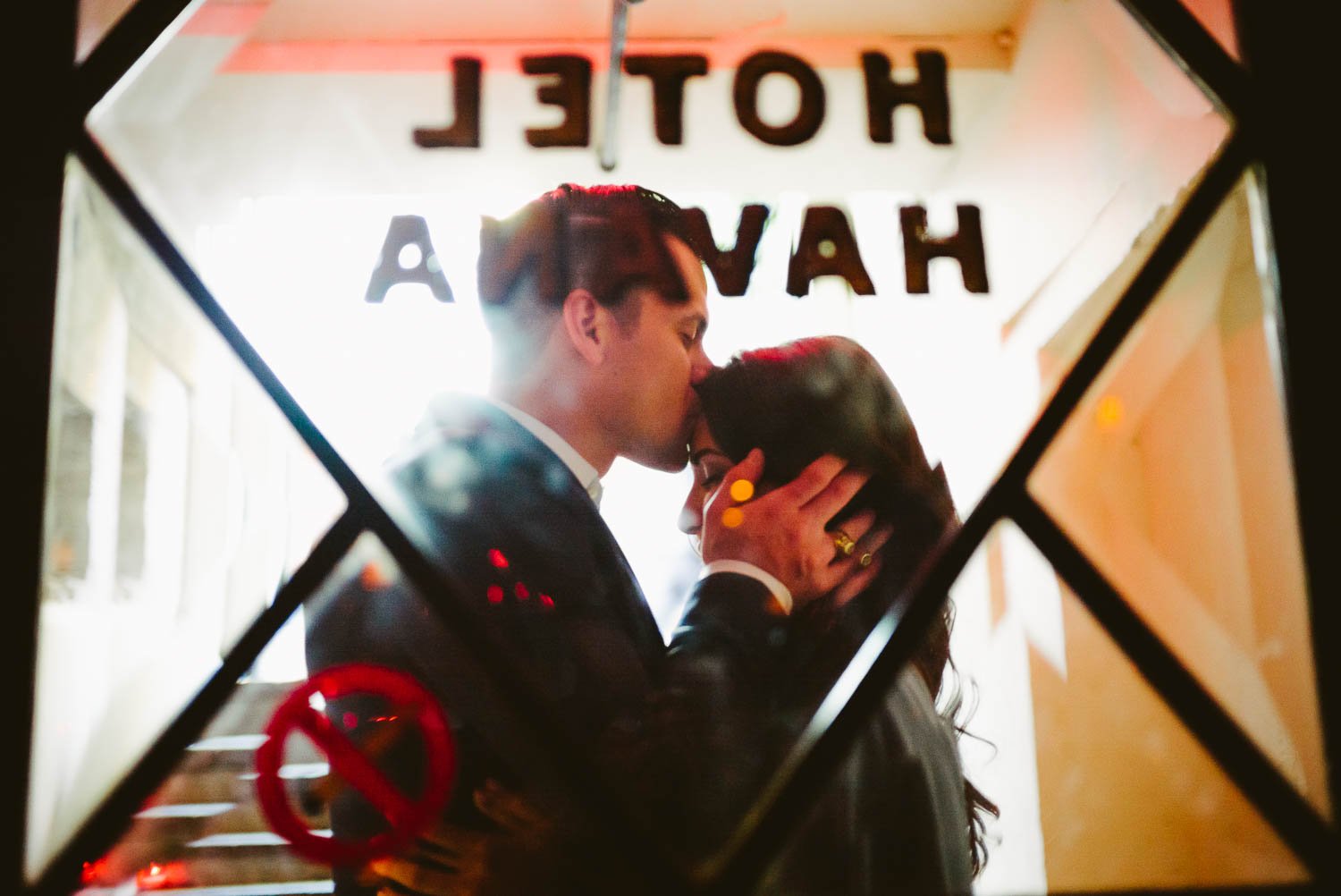 Lorenzo kisses Celina's forehead in Hotel Havana bar window Downtown San Antonio Engagement photos-04