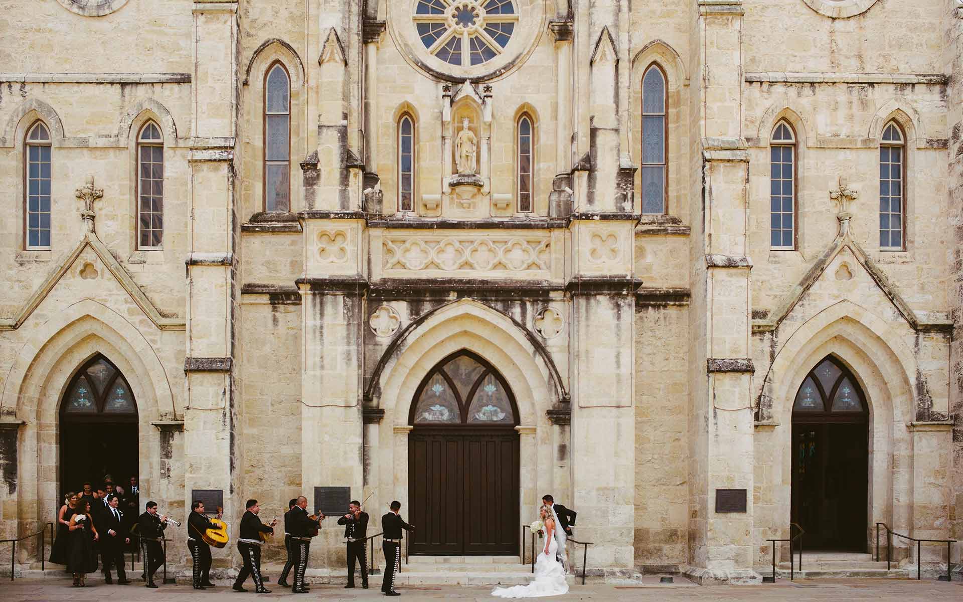 San Fernando Cathedral Wedding as couple greet guests and mariachis play in a July wedding - Photography by Leica wedding photographer Philip Thomas
