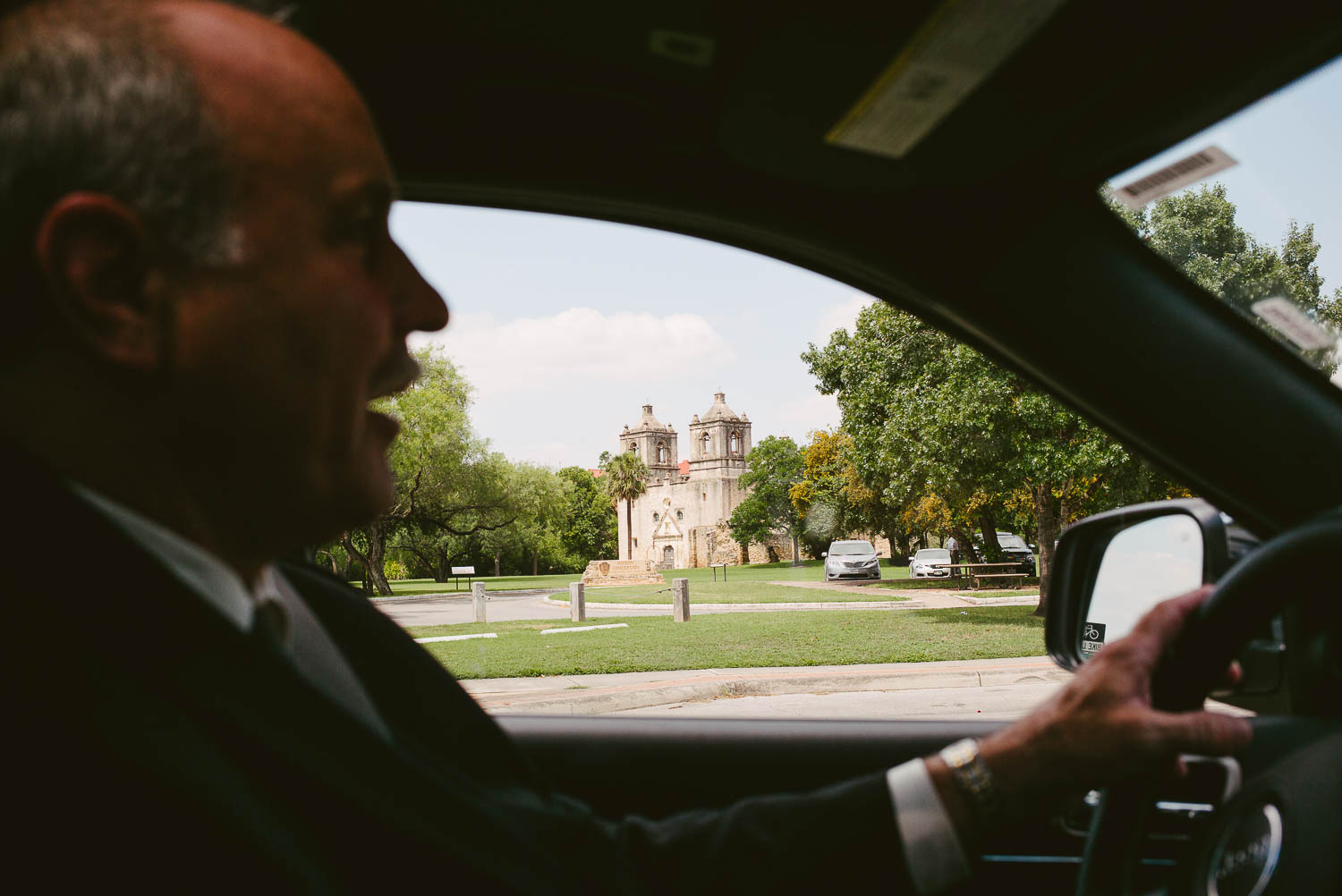 Father of the bride drives past the church Mission Concepcion Wedding-Leica photographer-Philip Thomas Photography