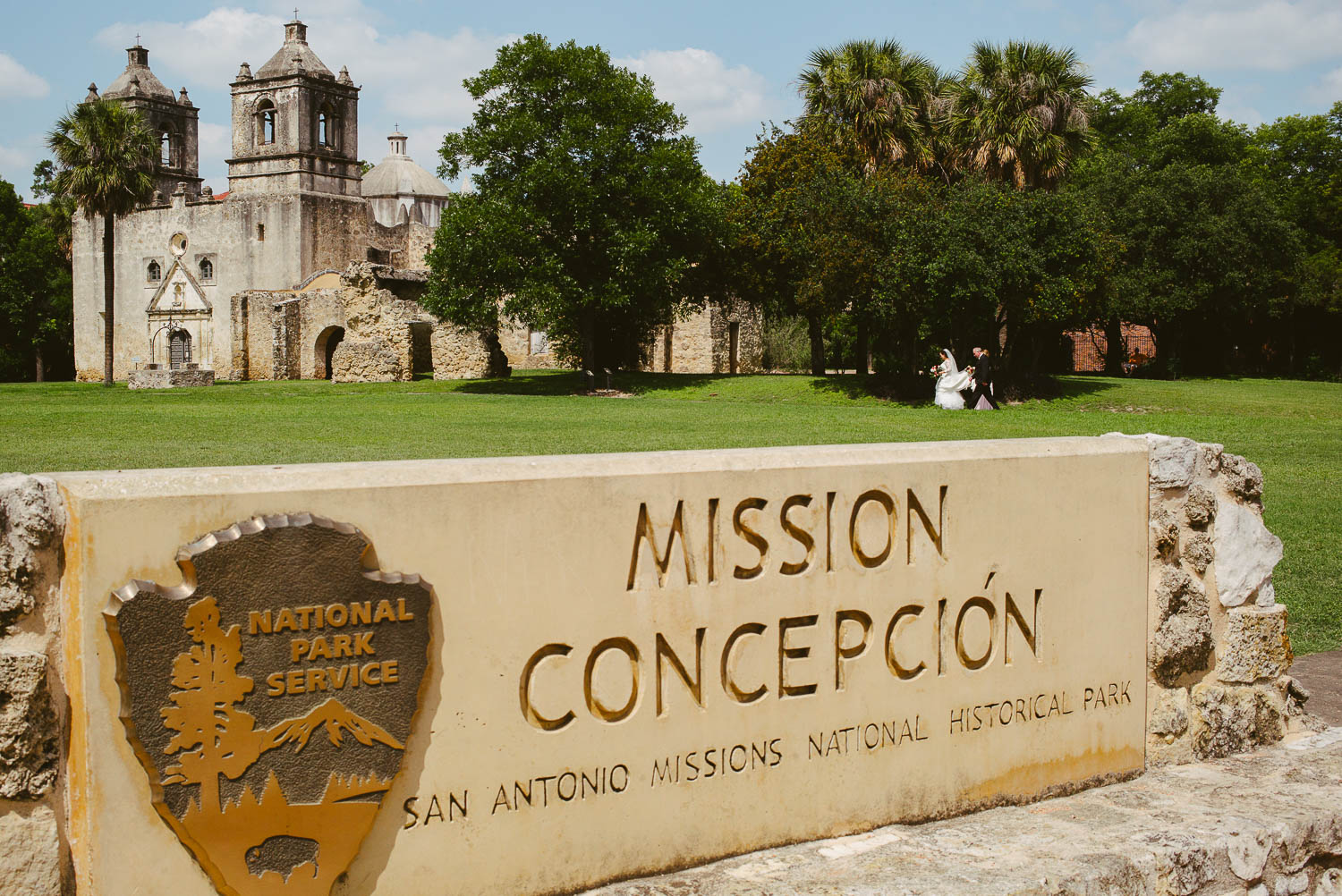 Bride and father walk from their parked car to the church as groom and friends family wait for her arrival - Mission Concepcion Wedding-Leica photographer-Philip Thomas Photography