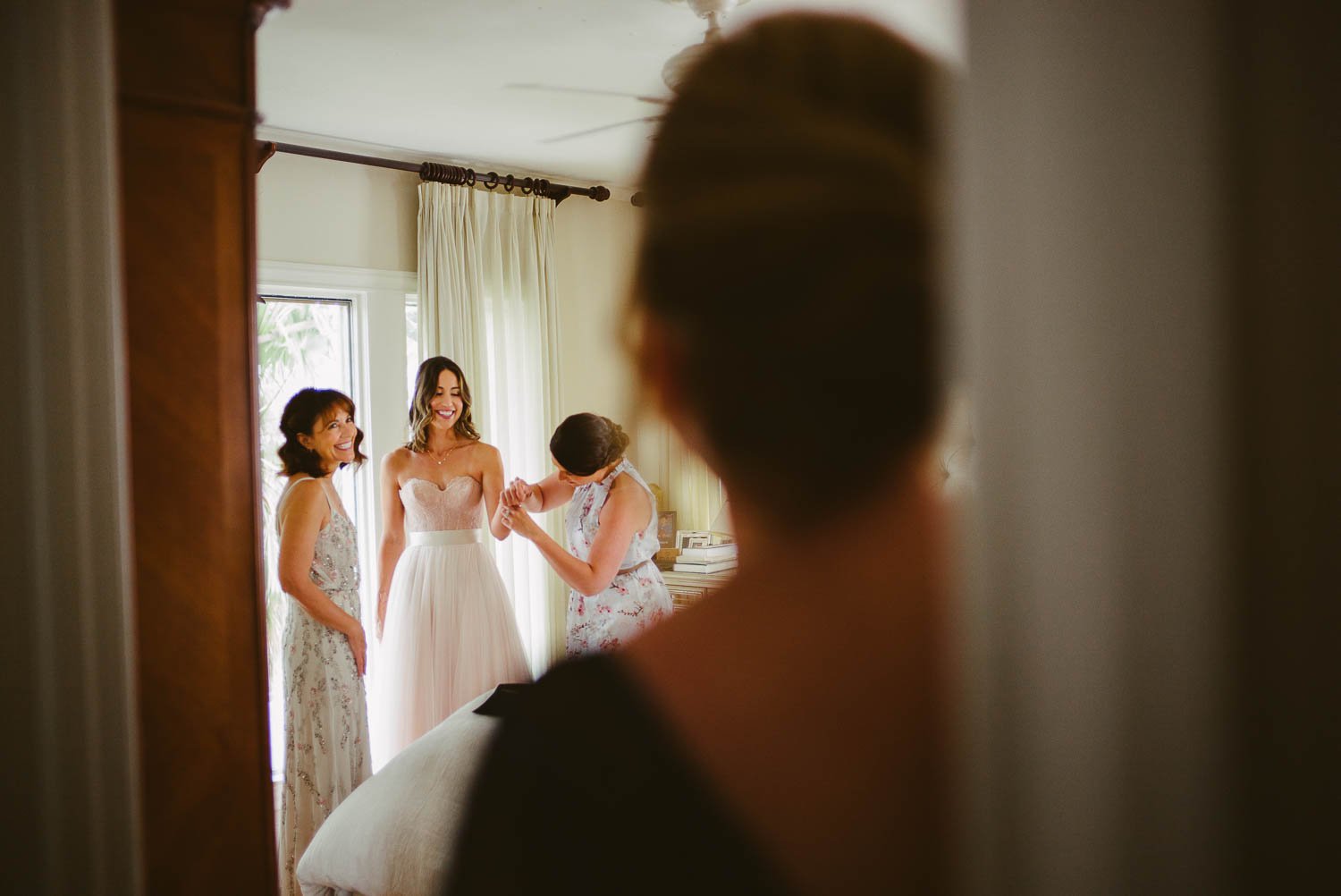 Mother of the bride, a friend and the bride are seen through the door frame of her Aunt's home on her wedding day, Houston Texas-Leica photographer-Philip Thomas Photography