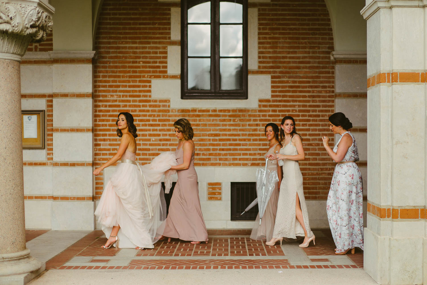 In-between heavy spring showers, the bride and bridesmaid stay sheltered at Rice University Houston Texas -Leica photographer-Philip Thomas Photography