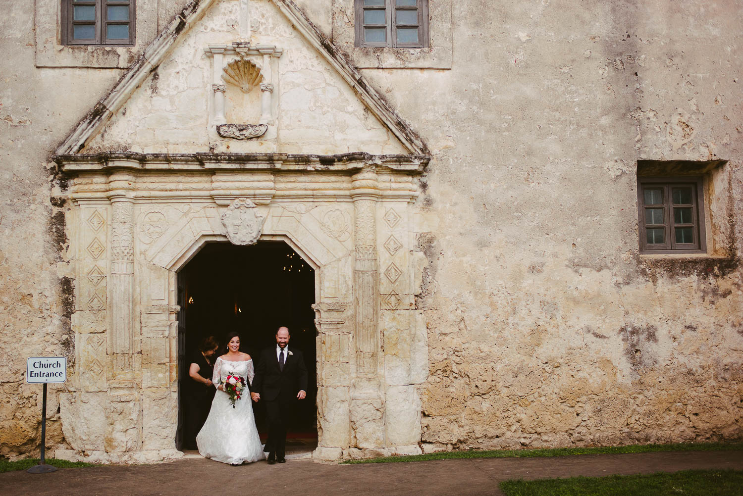 Just married couple first out of the door at Mission Concepcion Wedding-Leica photographer-Philip Thomas Photography