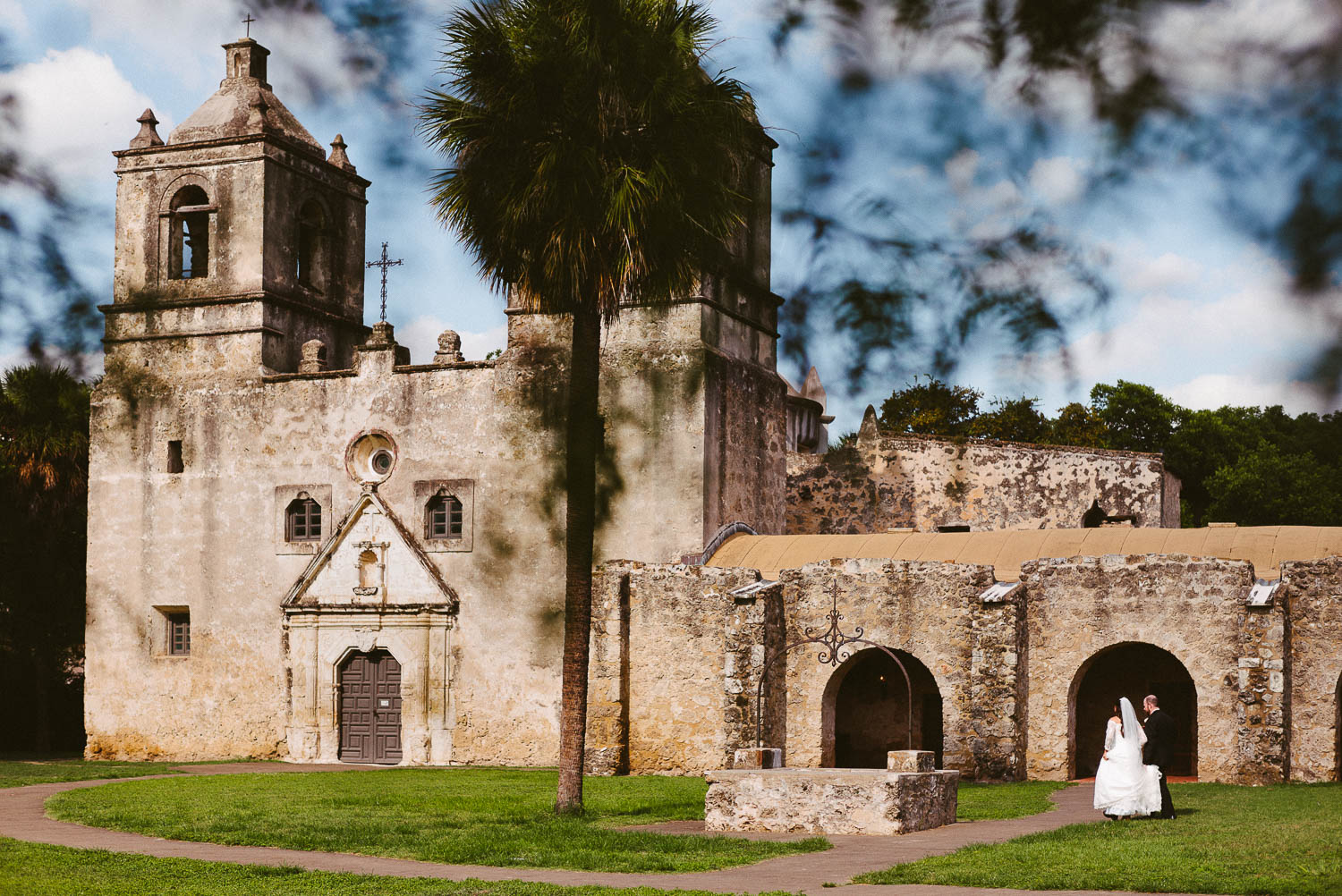 The wedded couple walk back toward Mission Concepcion Wedding-Leica photographer-Philip Thomas Photography