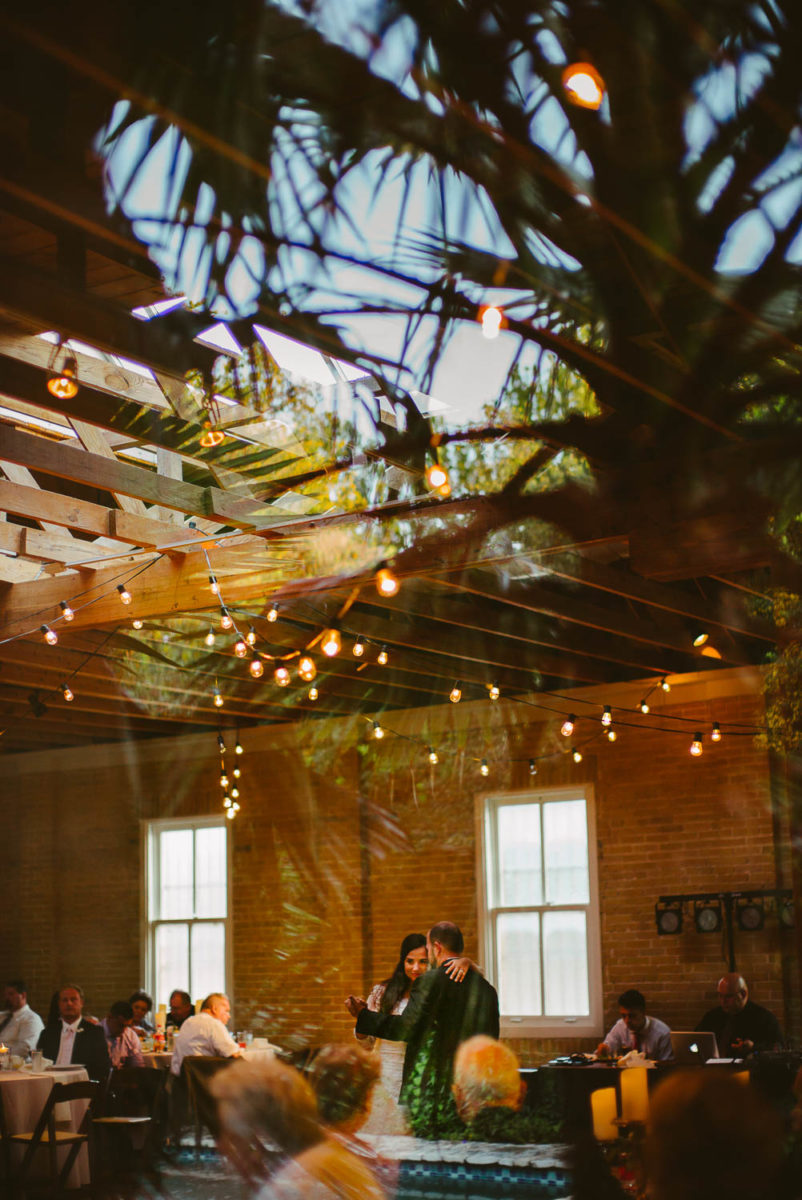 First dance bride and groom looking outside in through window wth palm trees Za Za Gardens Wedding Reception-Leica photographer-Philip Thomas Photography