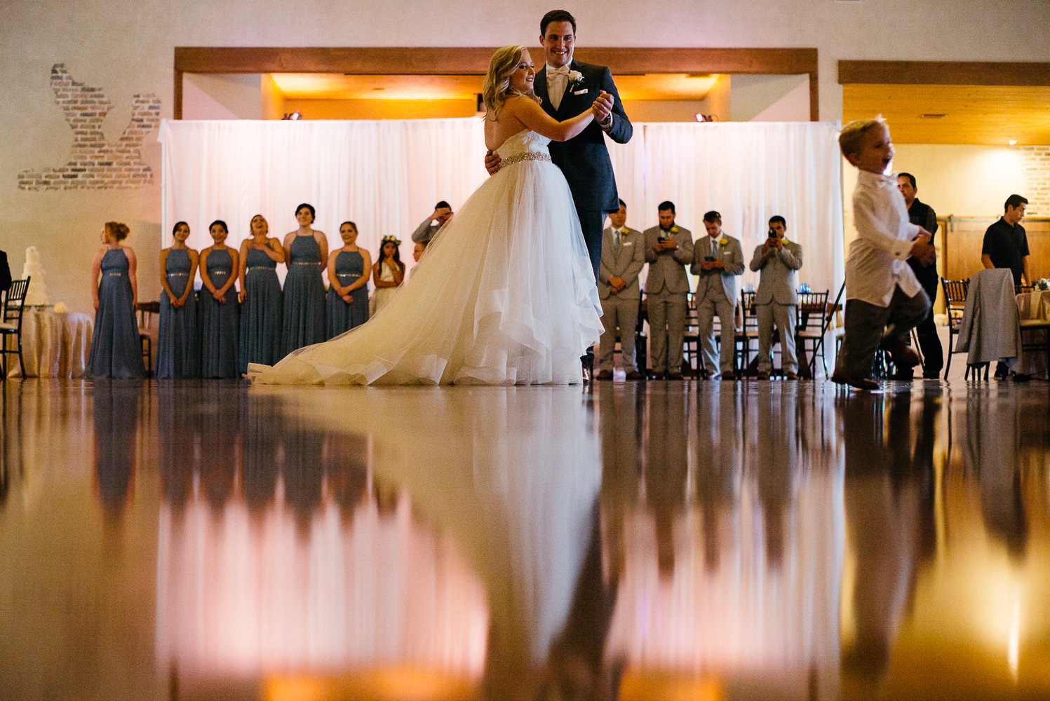 Bride and groom first dance low angle shows reflection Chandelier of Gruene Wedding Reception-30
