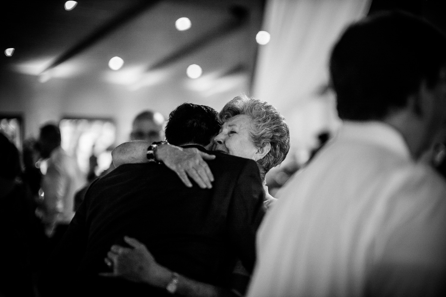 Emotional hug between senior lady and groom at Chandelier of Gruene Wedding Reception-38