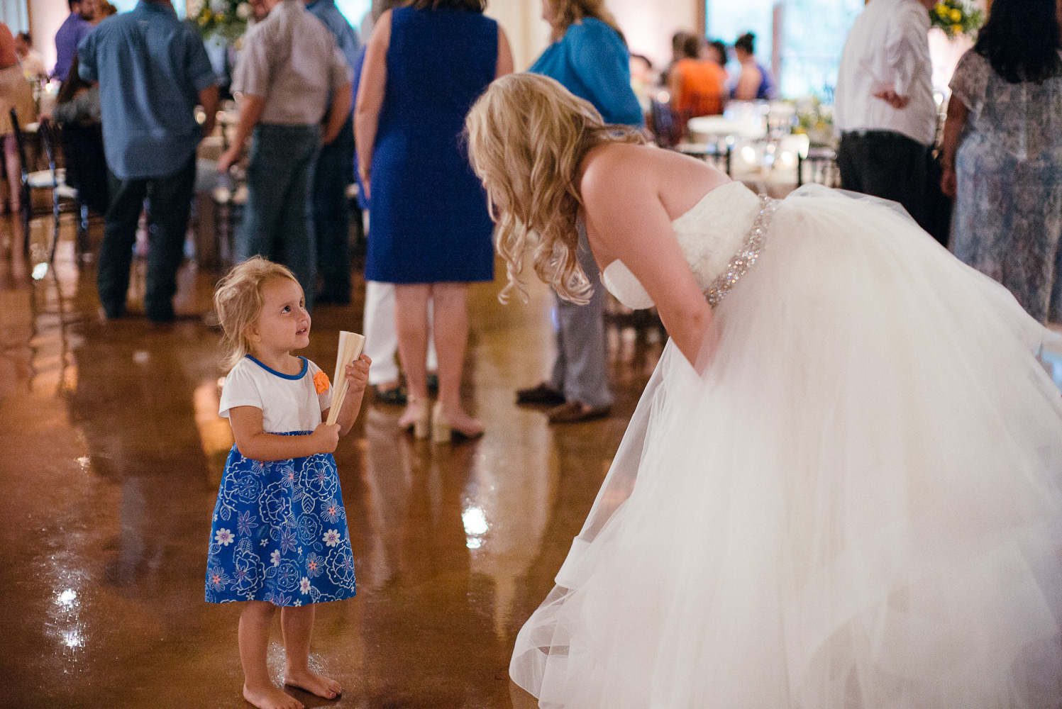 Little girl talks to bride at Chandelier of Gruene Wedding Reception-39