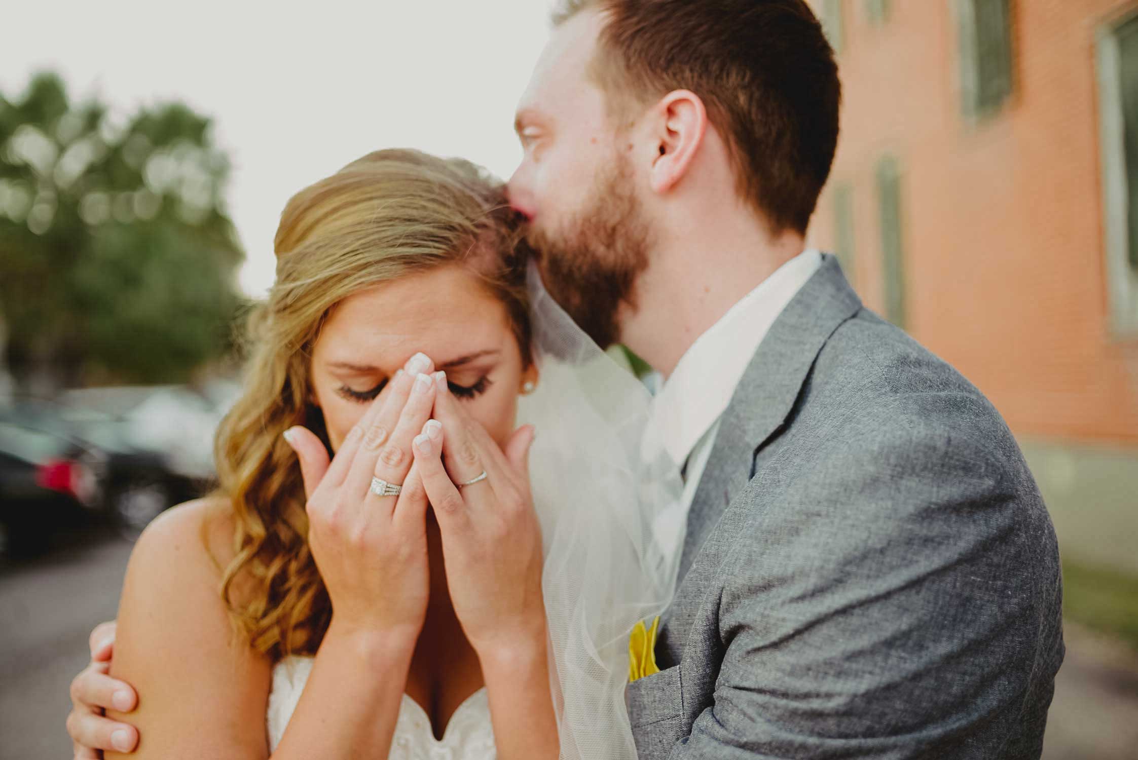 Emotional image showing bride and groom moments after getting married and calling her grandfather who could not attend wedding. Galveston, Texas photographed with a Leica M(240).