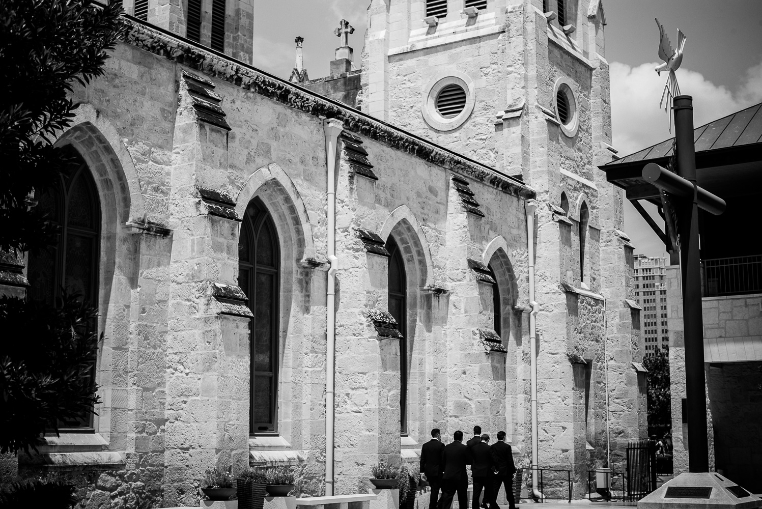Groomsmen male their way as a group toward entrance San Fernando Cathedral Wedding-16