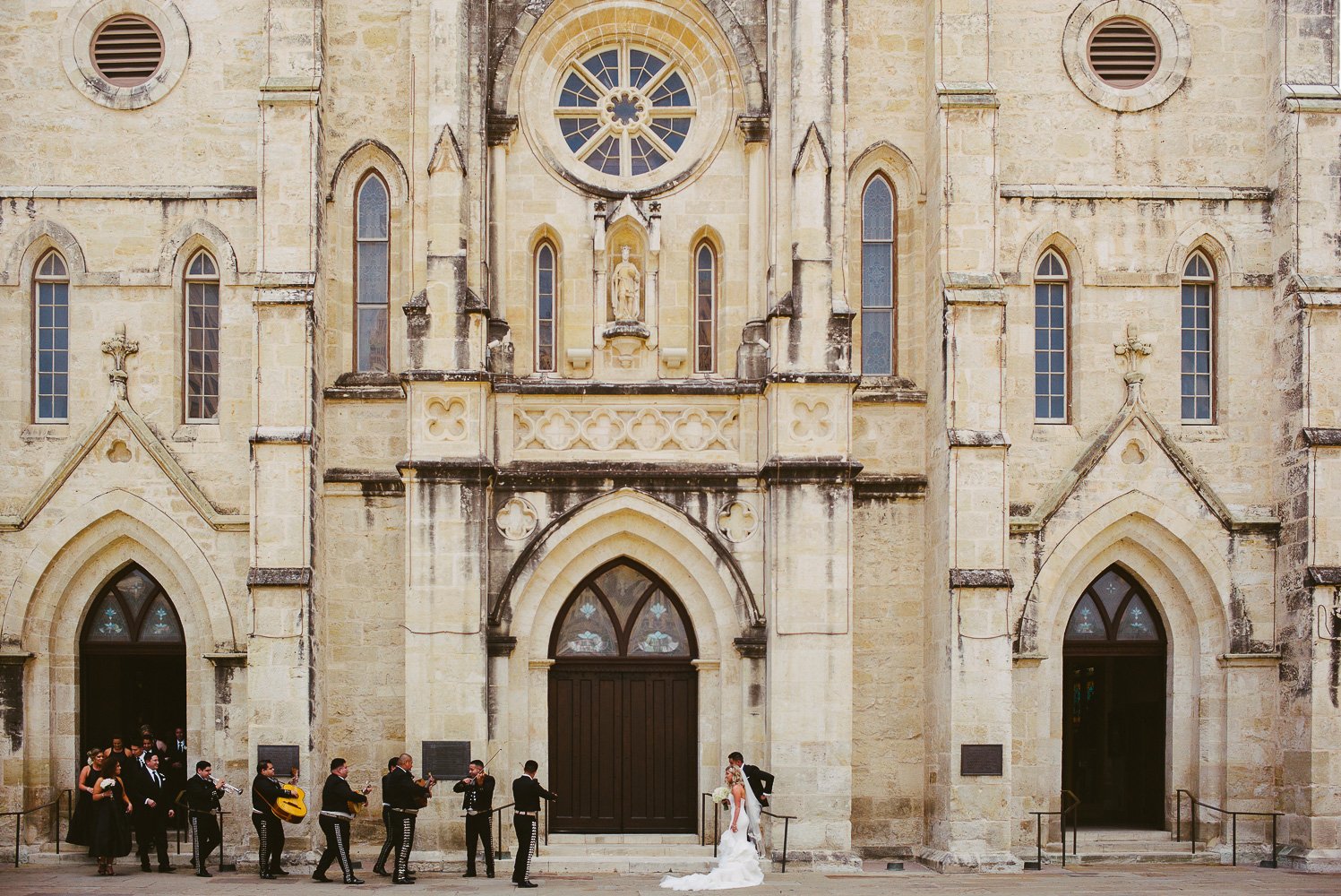 A favorite image at the bride and groom are played to by mariachis walking out of San Fernando Cathedral Wedding-27