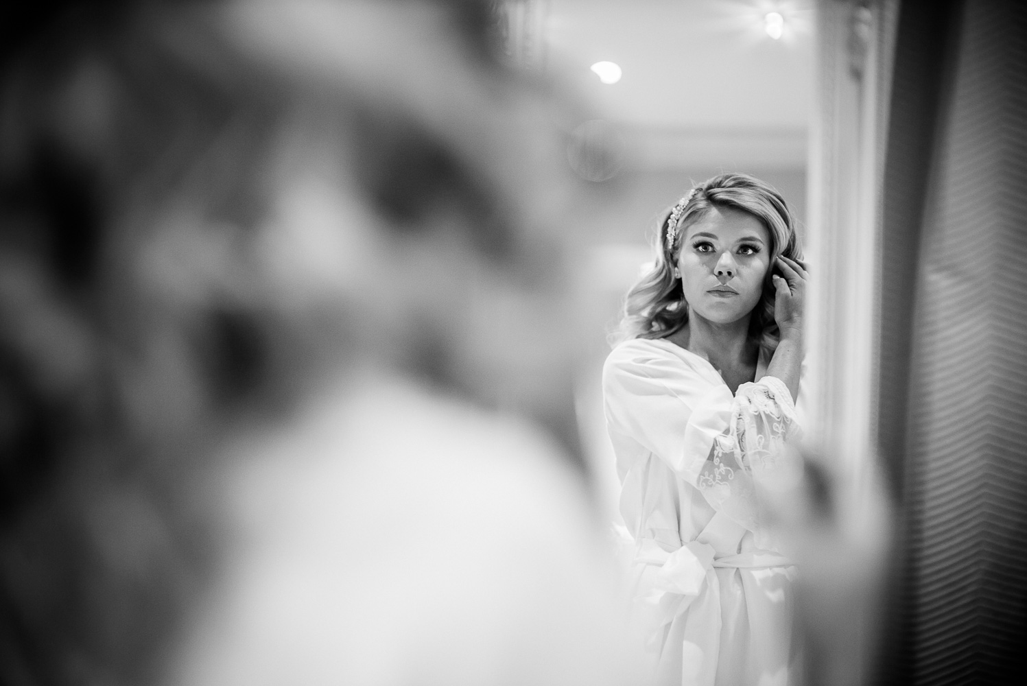 Bride checks the large mirror on her wedding day St Anthony Hotel Wedding-06