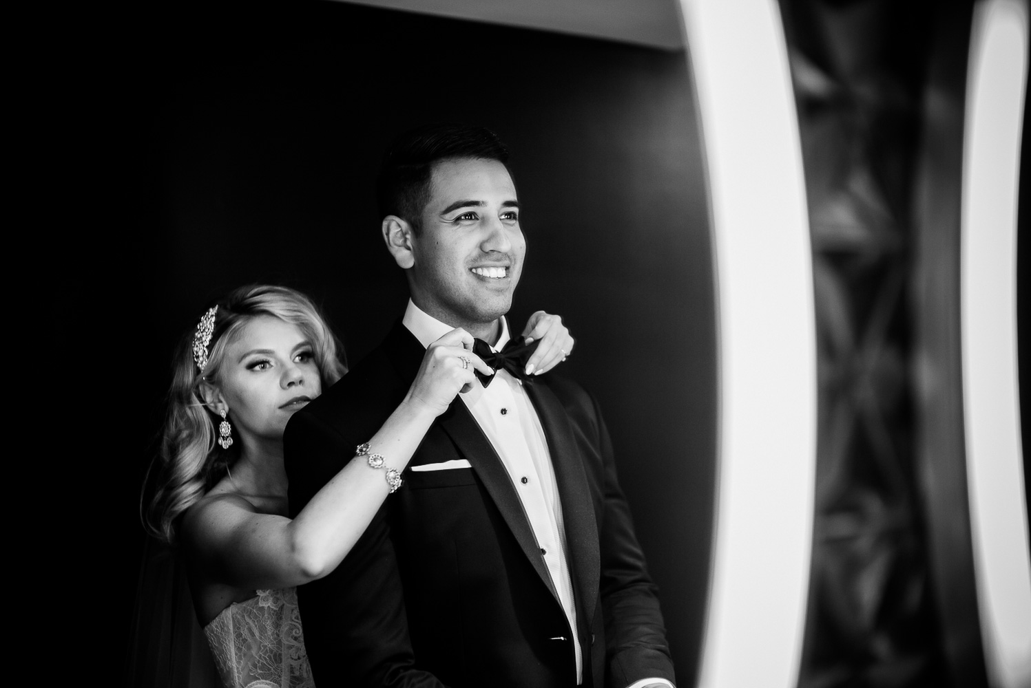 Bride fixes grooms tie in bathroom mirror St. Anthony Hotel San Antonio Wedding Reception-33