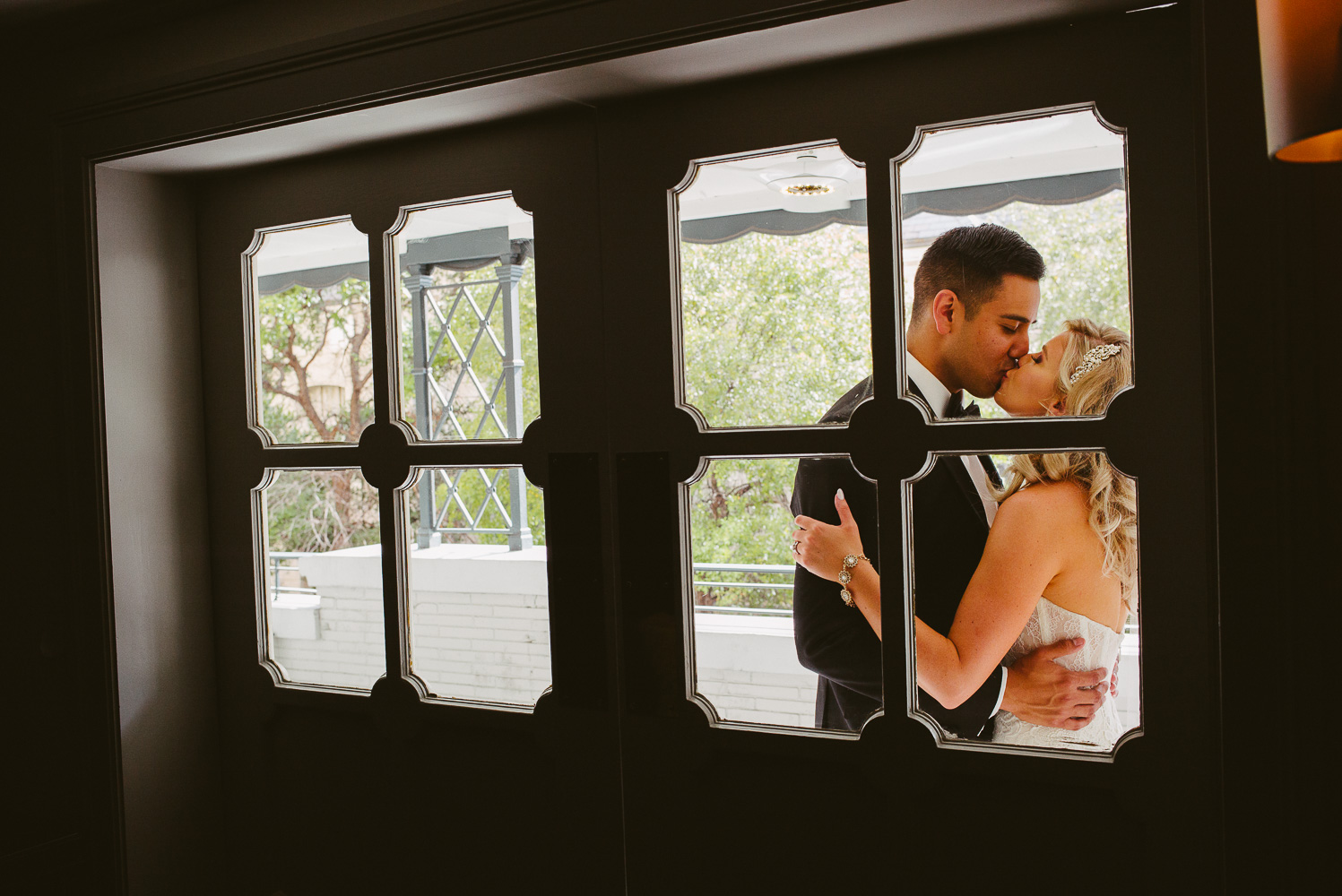 Couple on balcony just outside the library cafe at St. Anthony Hotel San Antonio Wedding Reception-35