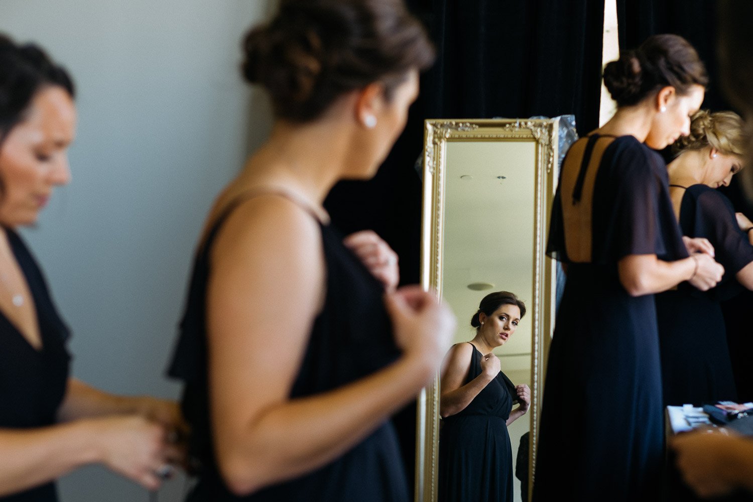 A bridesmaid checks herself in the mirror at Wedding St Anthony Reception-Philip Thomas