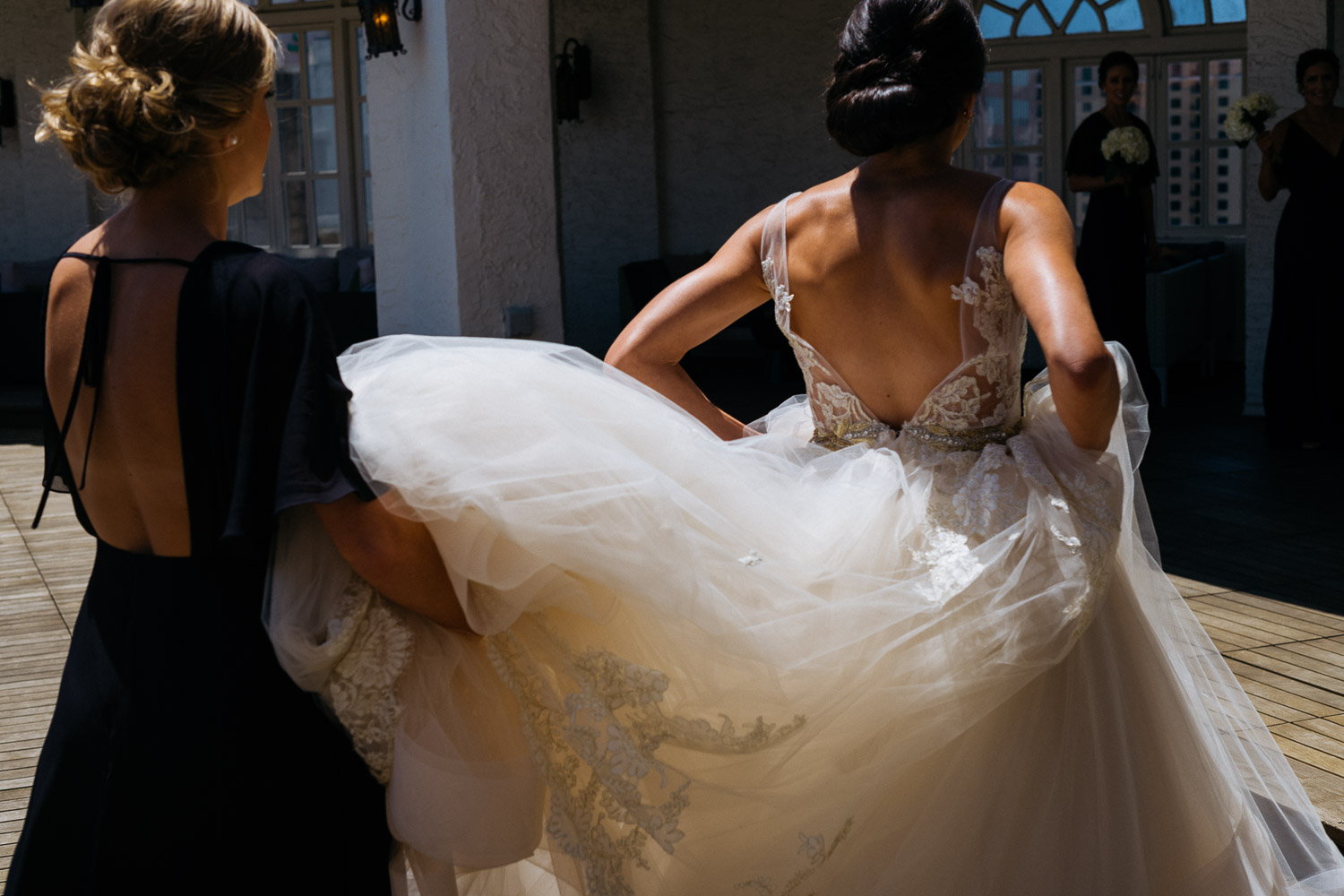 Brides dress is lifted up by bridesmaids St Anthony Reception-Philip Thomas