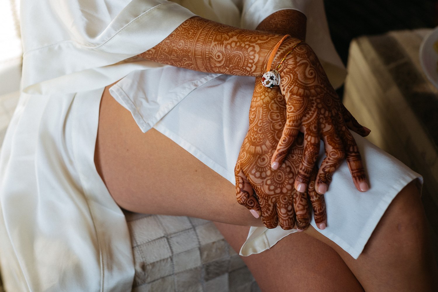 Bride rests her hands on legs showing henna tattoos Hindu Jewish fusion wedding Sugar Land Marriott Hotel Texas-014