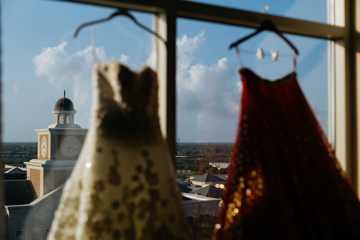 Two dresses hang - a Jewish wedding dress and a Hindu sari Hindu Jewish fusion wedding Sugar Land Marriott Hotel Texas-016