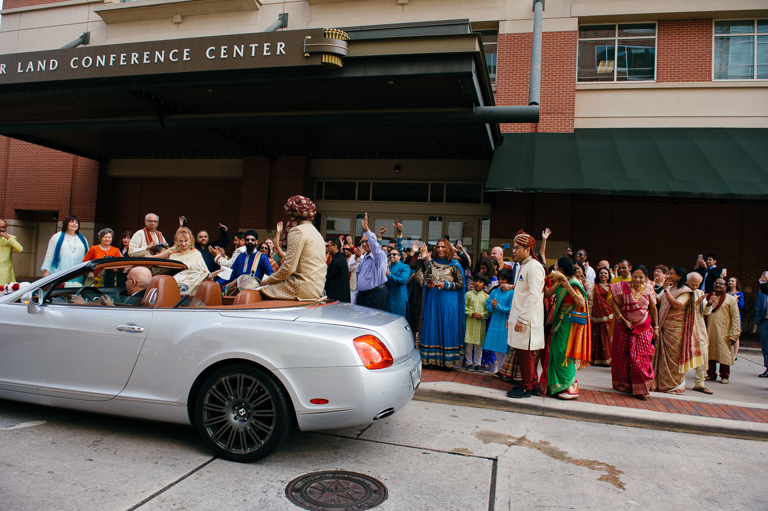 Groom on back of convertible during baraat Hindu Jewish fusion wedding Sugar Land Marriott Hotel Texas-030