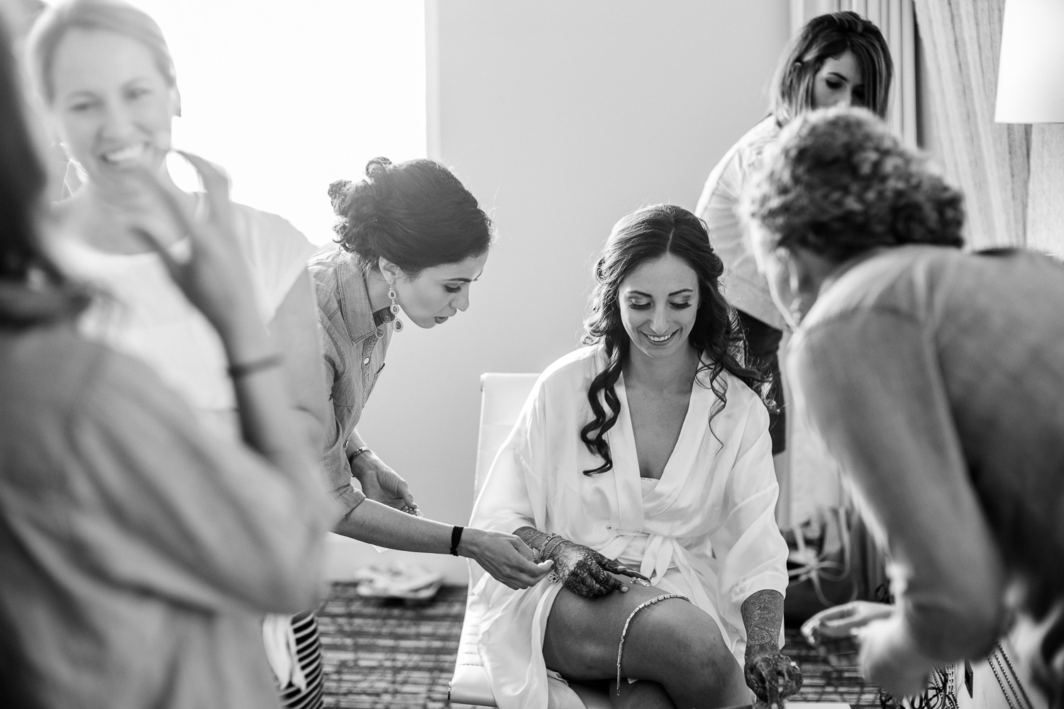 Brides gather round bride as he gets ready Hindu Jewish fusion wedding Sugar Land Marriott Hotel Texas-055