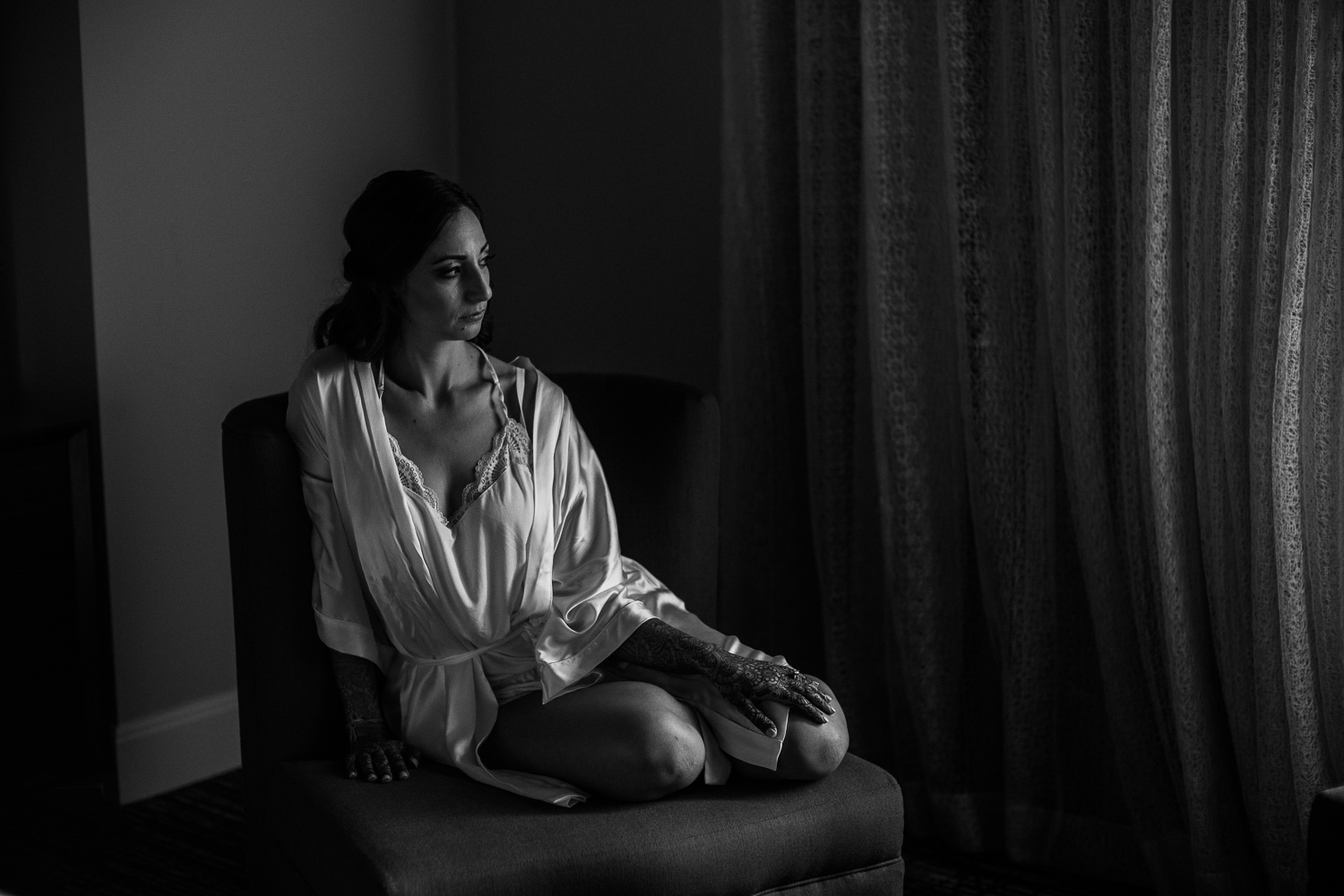 Bride sits in darkened room in negligee Hindu Jewish fusion wedding Sugar Land Marriott Hotel Texas-057