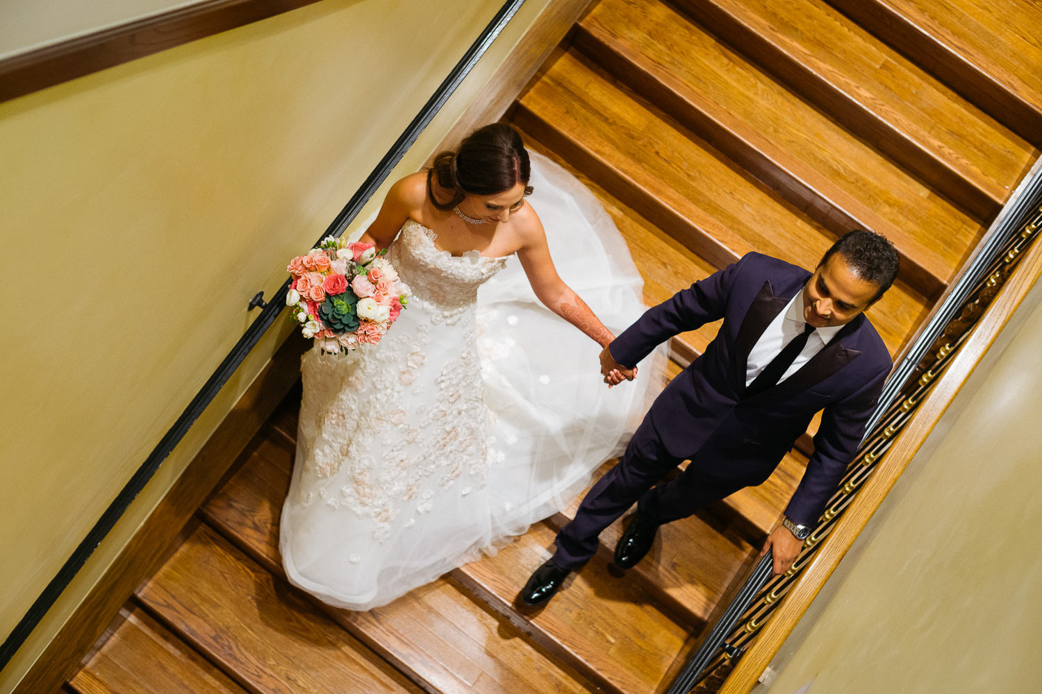 The married couple descend a staircase Hindu Jewish fusion wedding Sugar Land Marriott Hotel Texas-062