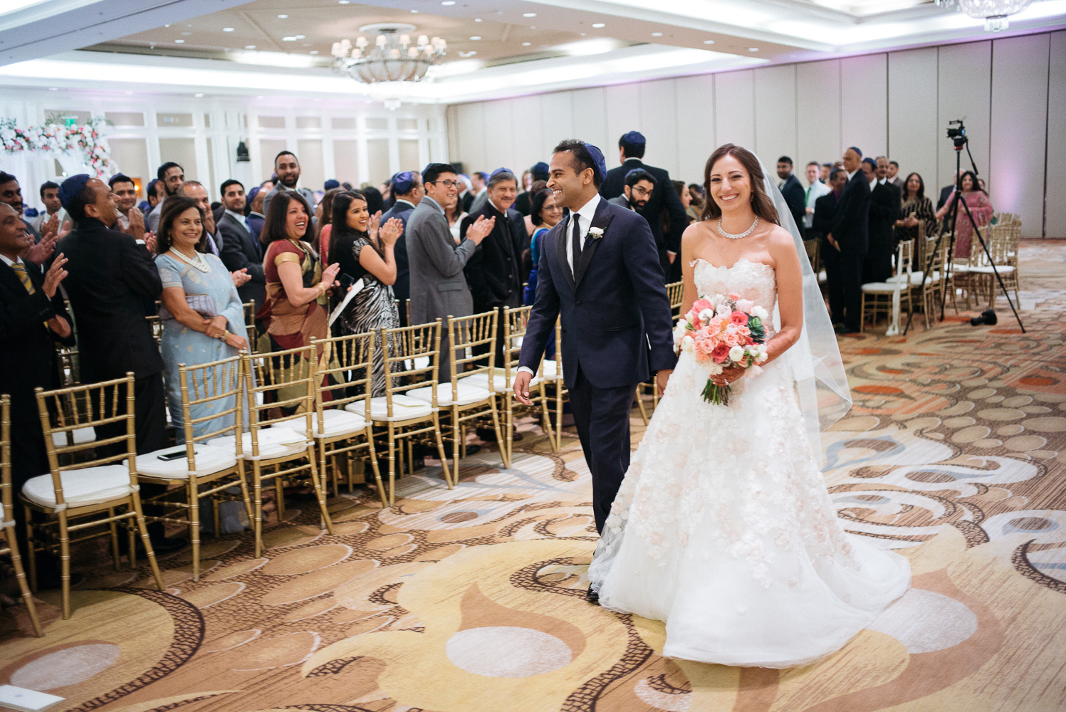 Couple celebrate as they walk down the aisle Hindu Jewish fusion wedding Sugar Land Marriott Hotel Texas-073