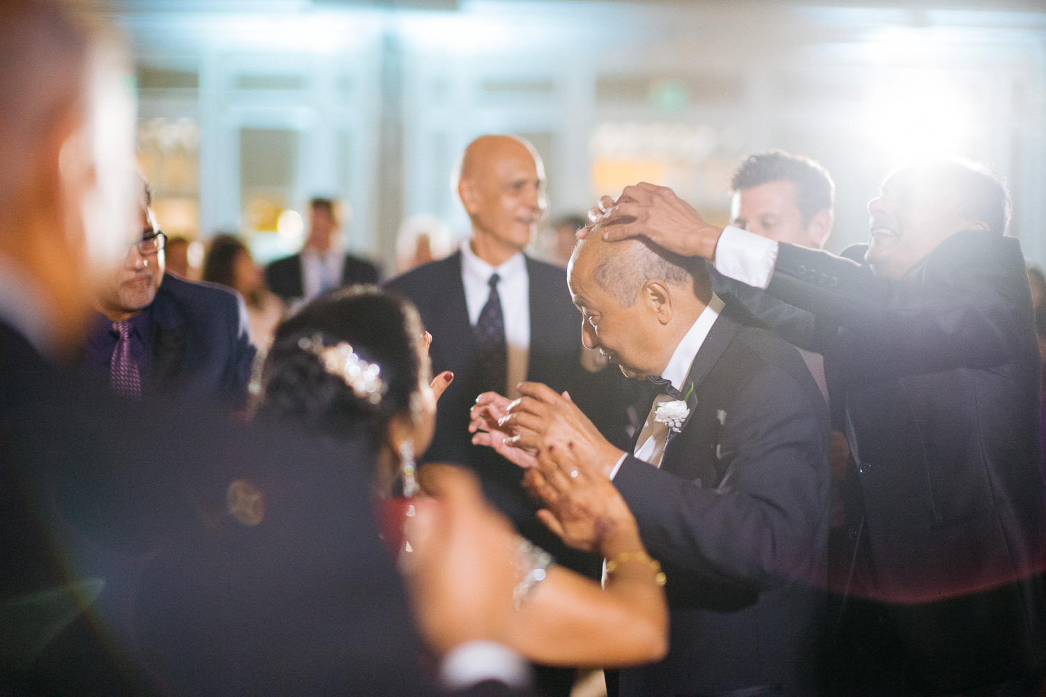 Friends of father playfuly play with his hair during wedding reception Hindu Jewish fusion wedding Sugar Land Marriott Hotel Texas-097