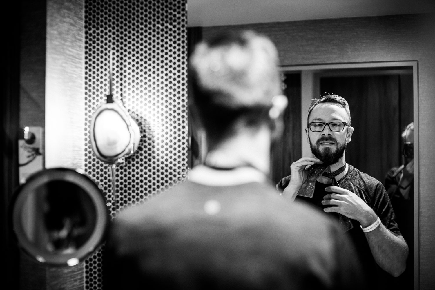 Groom fixes tie in mirror at JW Marriott Austin Wedding Photos-Philip Thomas