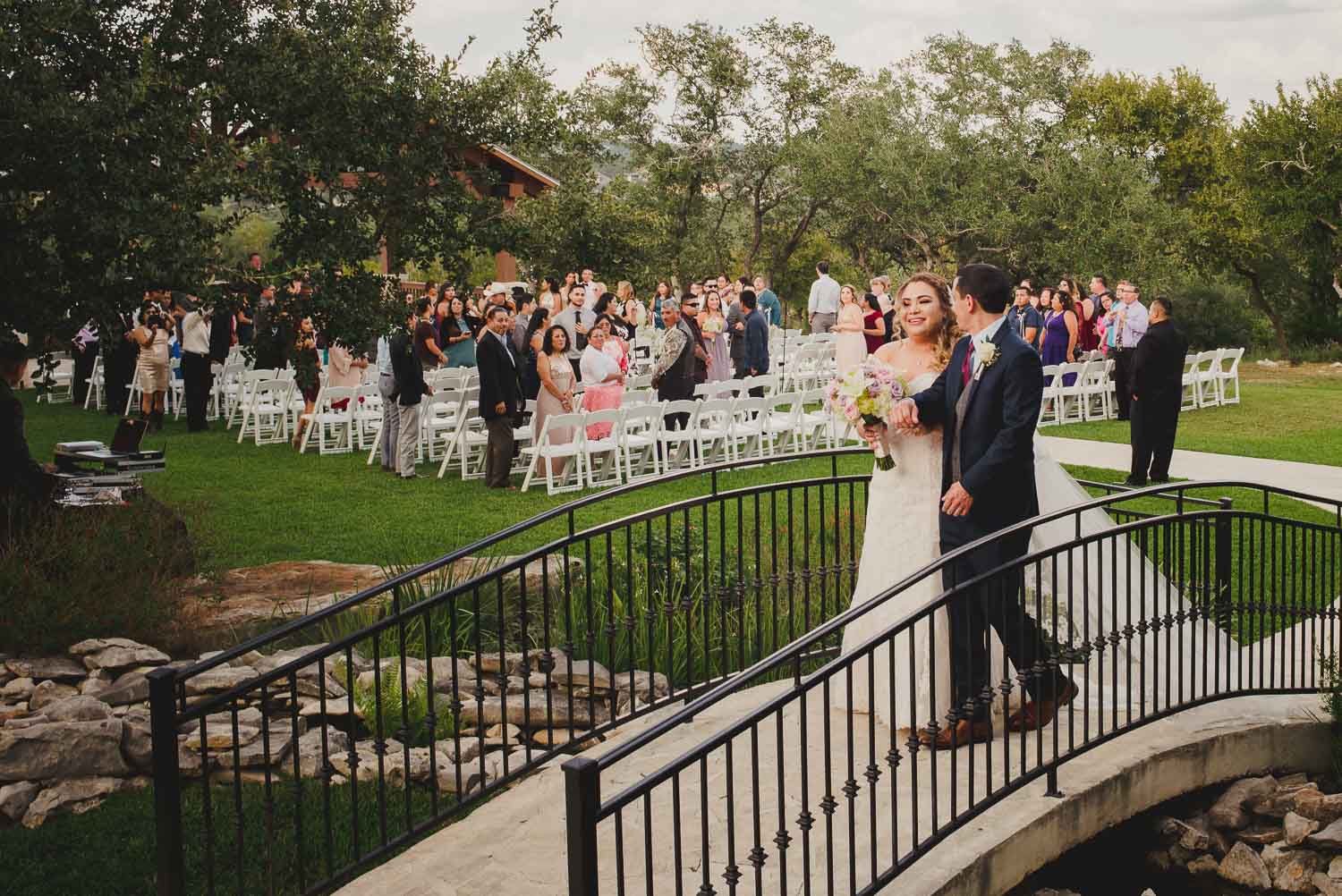 Couple cross the bride as they walk down the aisle at The Springs Event Venue Wedding Photos-Philip Thomas
