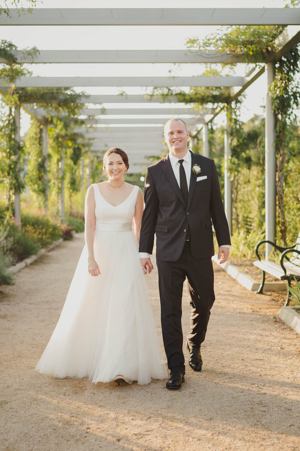 Couple walk through trellis at sunset on their wedding day Cherie Flores Garden Pavilion Wedding Hermann Park Houston Texas-Philip Thomas