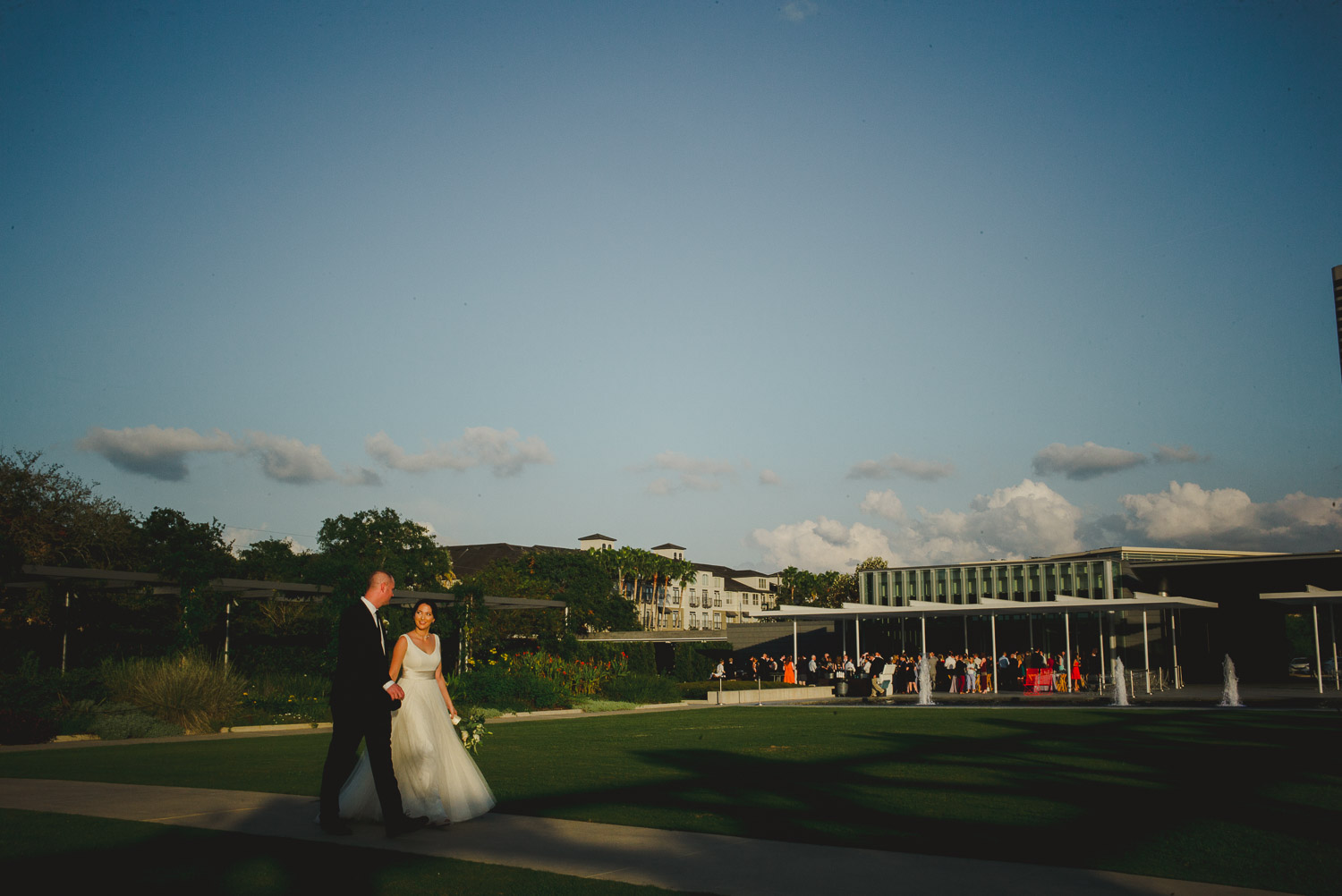 Just married couple stride across park at Cherie Flores Garden Pavilion Wedding Hermann Park Houston Texas-Philip Thomas