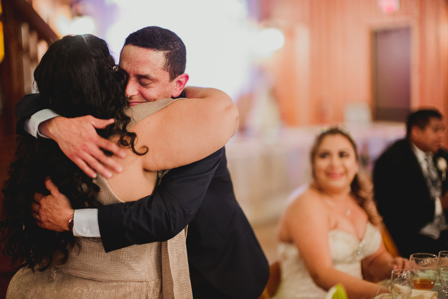Eric the groom hugs his mother in law after an emotional speech with the bride looking on at The Springs Event Venue Wedding Photos-Philip Thomas