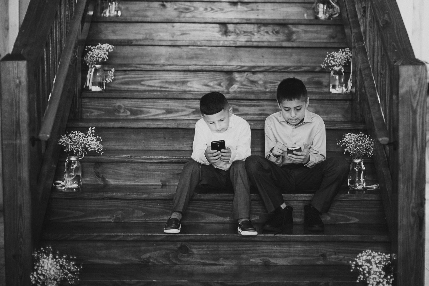 Two boys sit on staircase during a wedding reception at The Springs Event Venue Wedding Photos-Philip Thomas