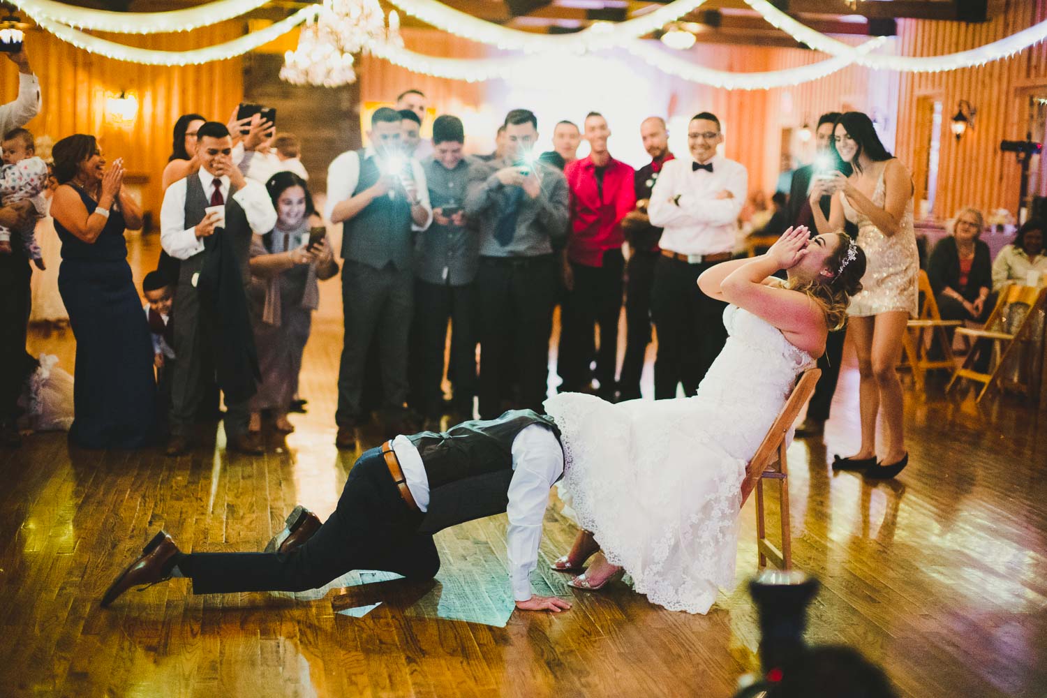 Funny and hilarious image as groom retrieve brides garter atThe Springs Event Venue Wedding Photos-Philip Thomas