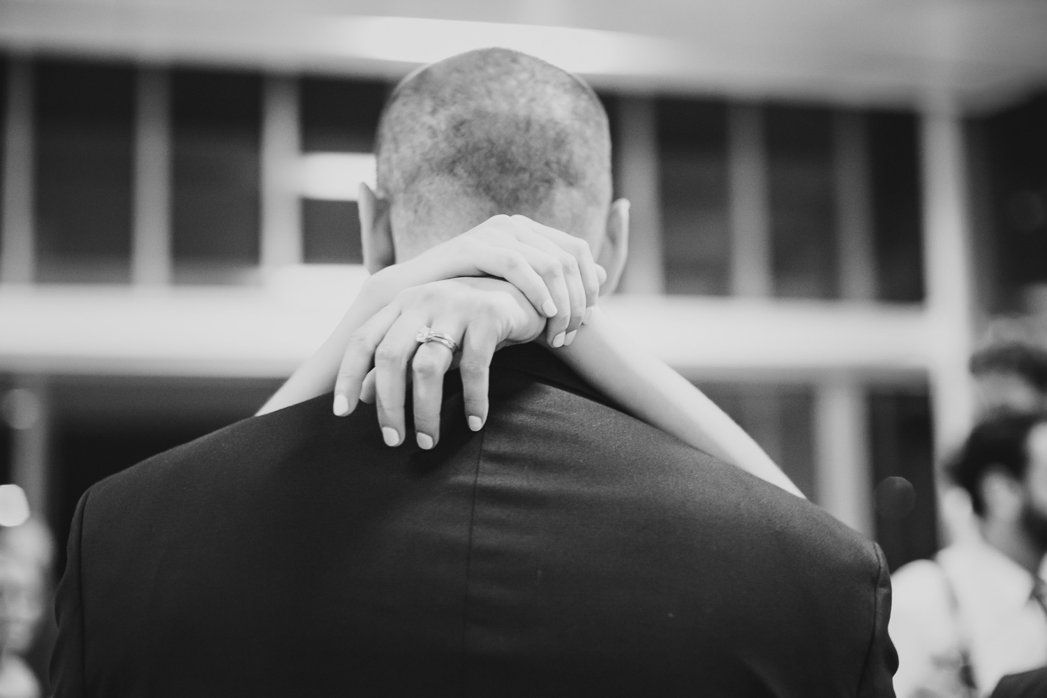 Chrostine's hands wrapped around the neck of Justin, the groom at Cherie Flores Garden Pavilion Wedding Hermann Park Houston Texas-Philip Thomas