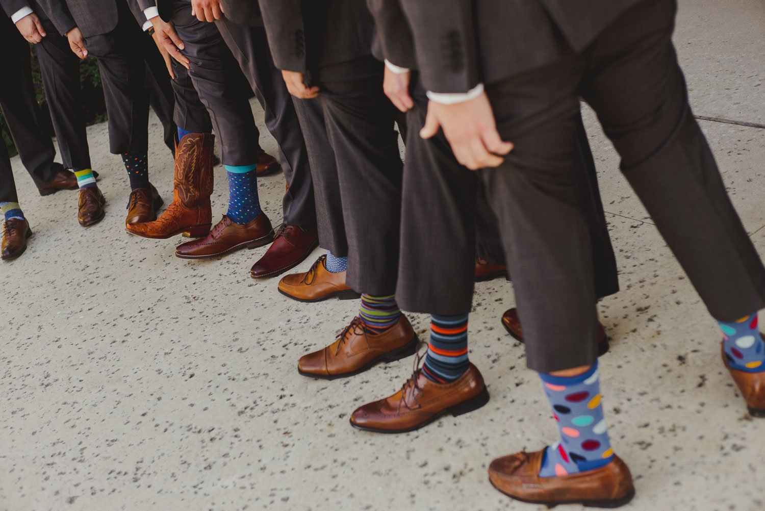 Groomsmen show socks during group photo session at -Paniolo Ranch Wedding Reception-Philip Thomas