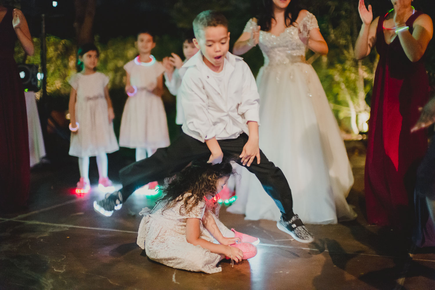 Boy hops over little girls during wedding reception dancing at Paesanos 1604 Wedding Reception-Philip Thomas