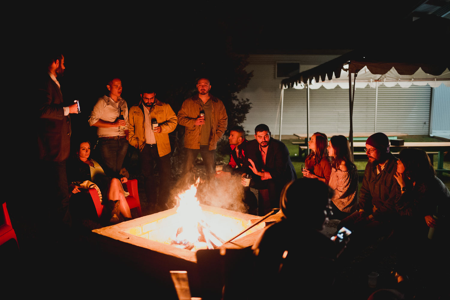 The wedding party surrounds a camp fire at rehearsal dinner Liney moon DRIPPING SPRINGS _ BRANDI + AJ-01