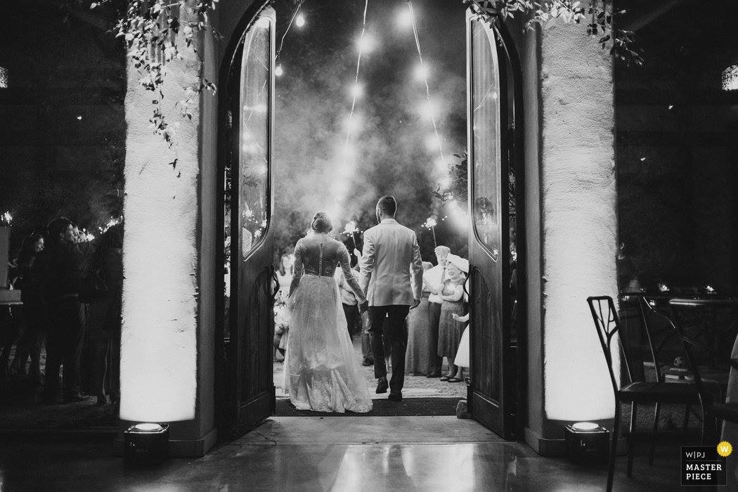 Couple hold hands walk through a sparkler exit captured from behind at Barr Mansion -Thrilled to see my pic win in the WPJA 2017 Tri-3 Contest - SEND OFF / DEPARTURE - 2nd Place - Photo By: Philip Thomas from San Antonio, Texas