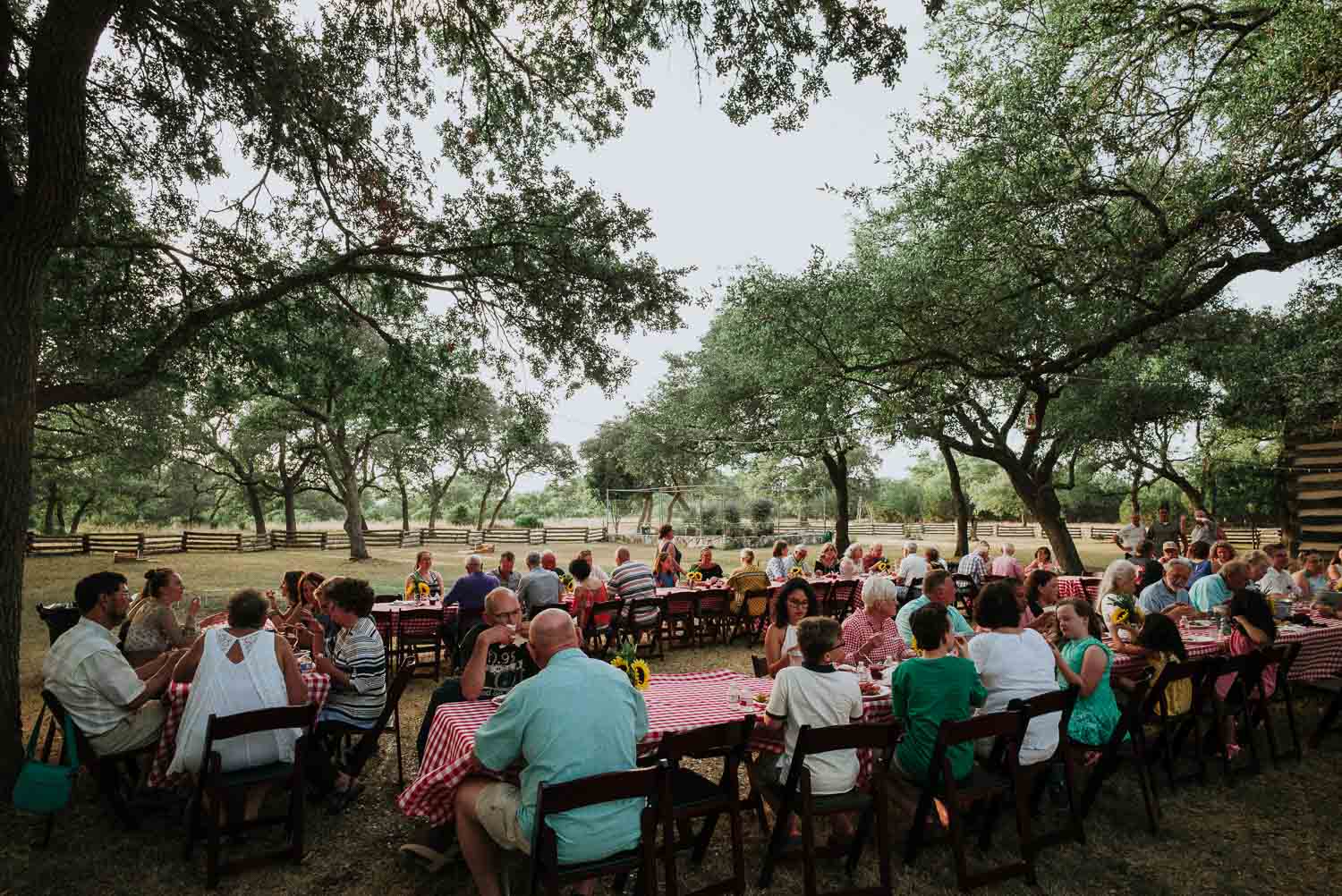 Friends and family gather round long table setups at a wedding rehearsal dinner