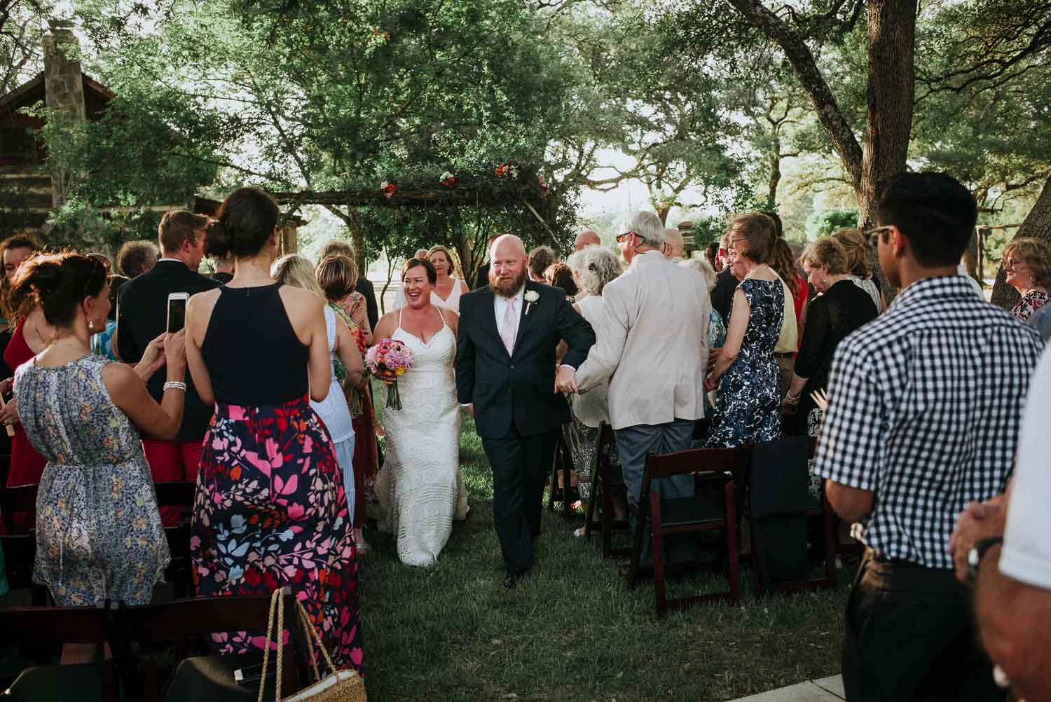 The newly married couple joyfully walk down the aisle.