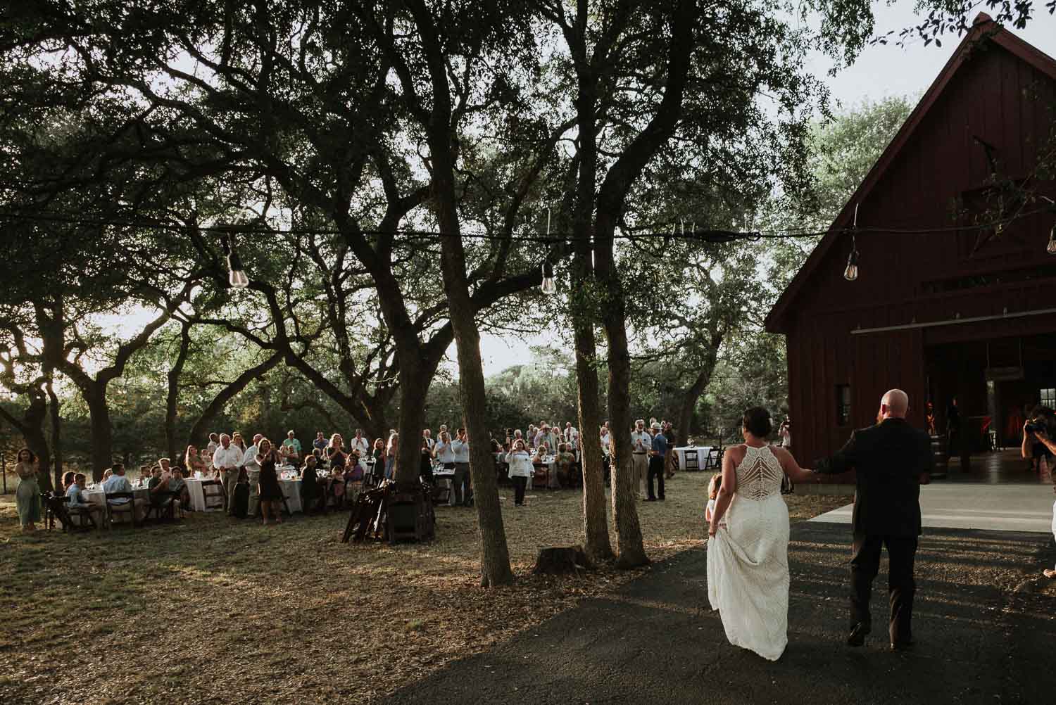 The newly married couple are seen walking toward their wedding reception with guests waiting to greet them