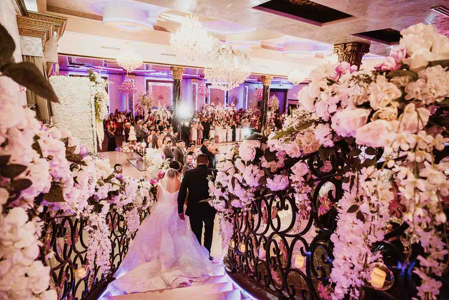 The couple walk down the staircase Villa De Palmer, McAllen decor wedding reception