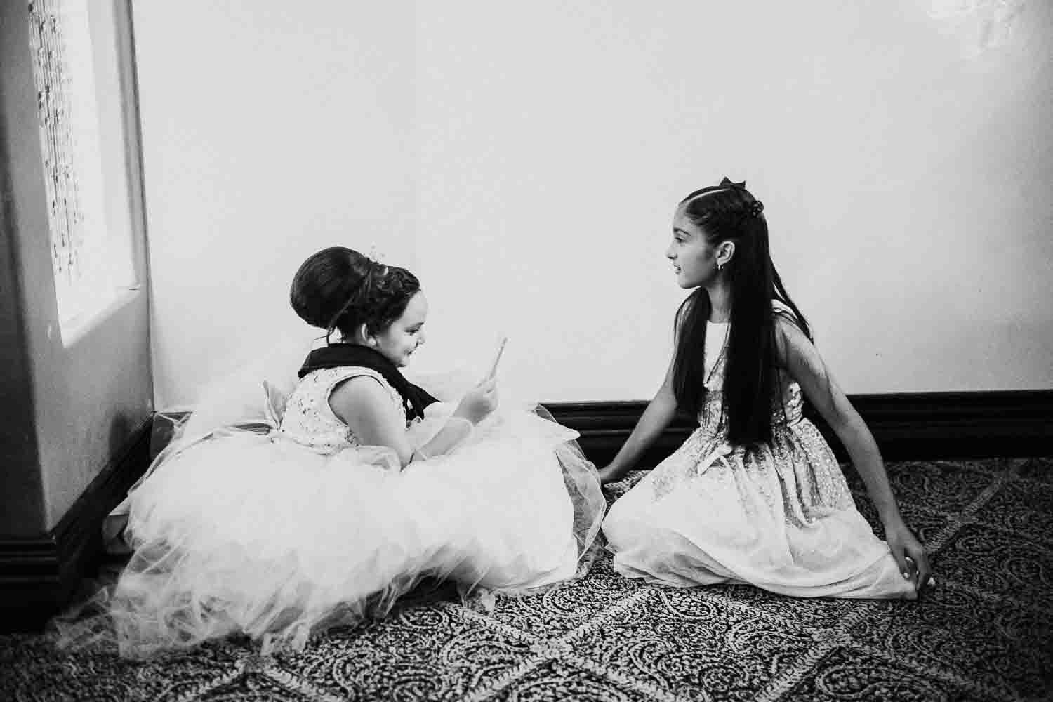 Two girls beneath a staircase play together Clarissa and Eric Villa De Palmer, McAllen decor wedding reception