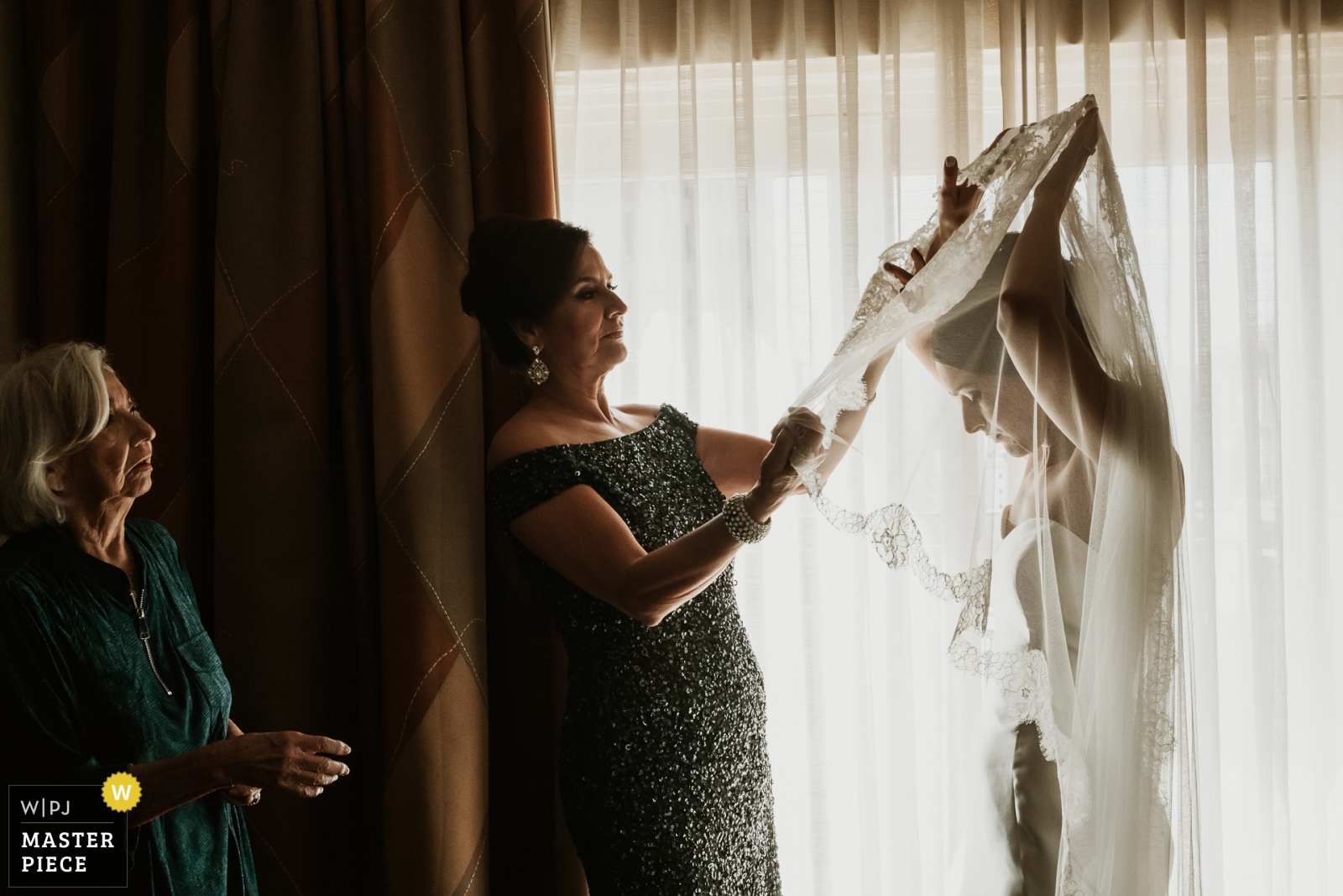 Mother and grandmother of the bride help bride with her veil at The Westin Riverwalk in San Antonio Texas - WPJA Award winning image