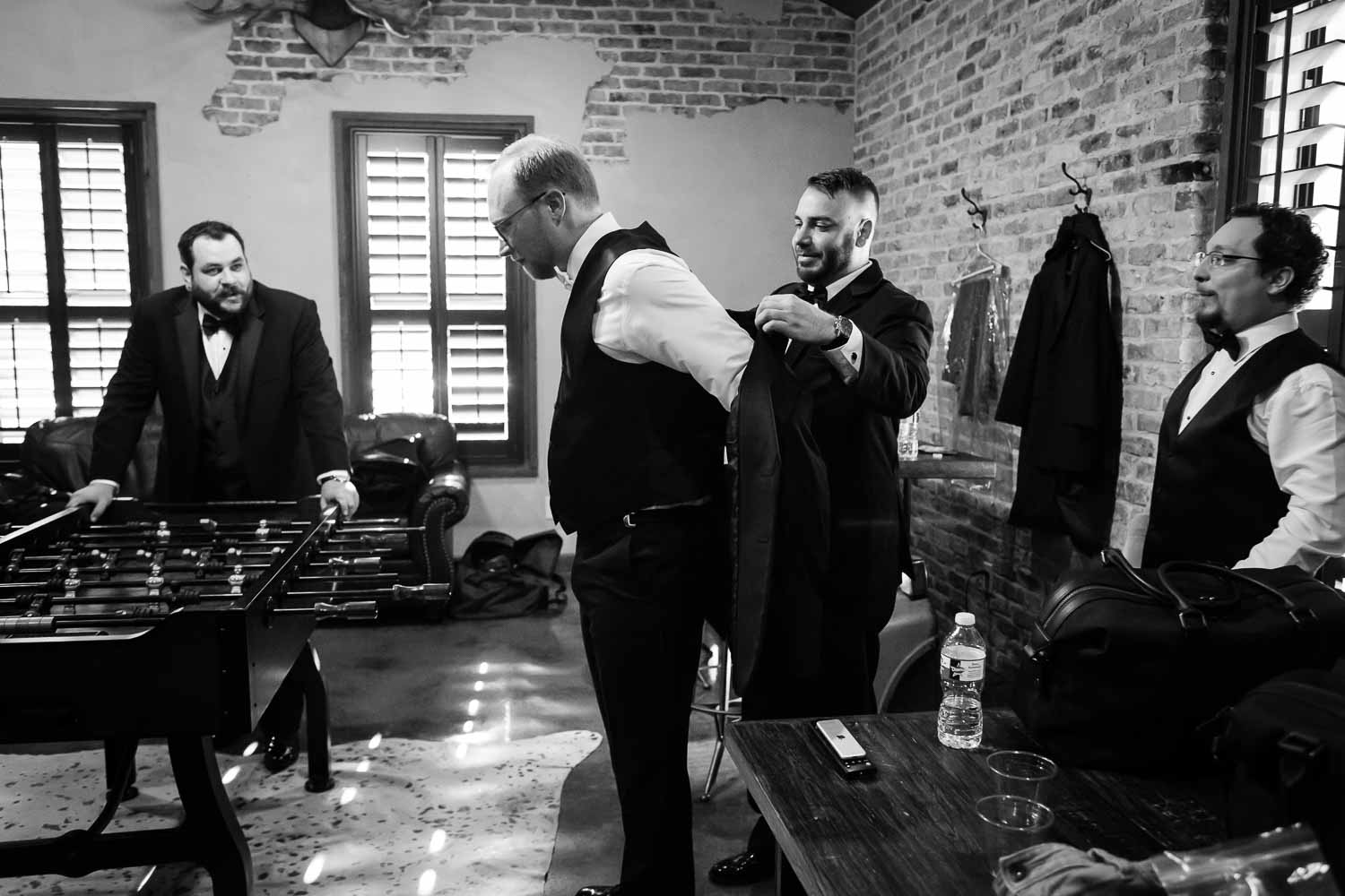James thr groom has help from best man putting on his jacket 03 The Chandelier of Gruene Wedding Photos -2019-01-09_0001-Philip Thomas Photography