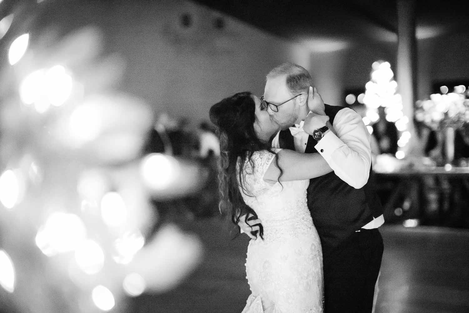 The couple embrace and kiss on their last dance with a Christmas tree in the foreground-The Chandelier of Gruene Weding Photos -L1004812-Philip Thomas Photography