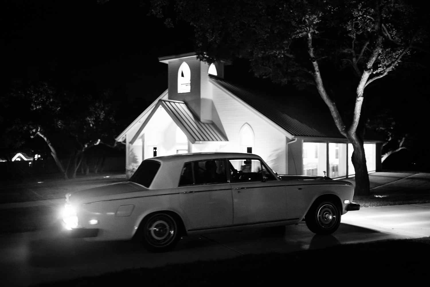 A Rolls-Royce departs with happy couple with the chapel in the background 54-The Chandelier of Gruene Weding Photos -L1004860-Philip Thomas Photography