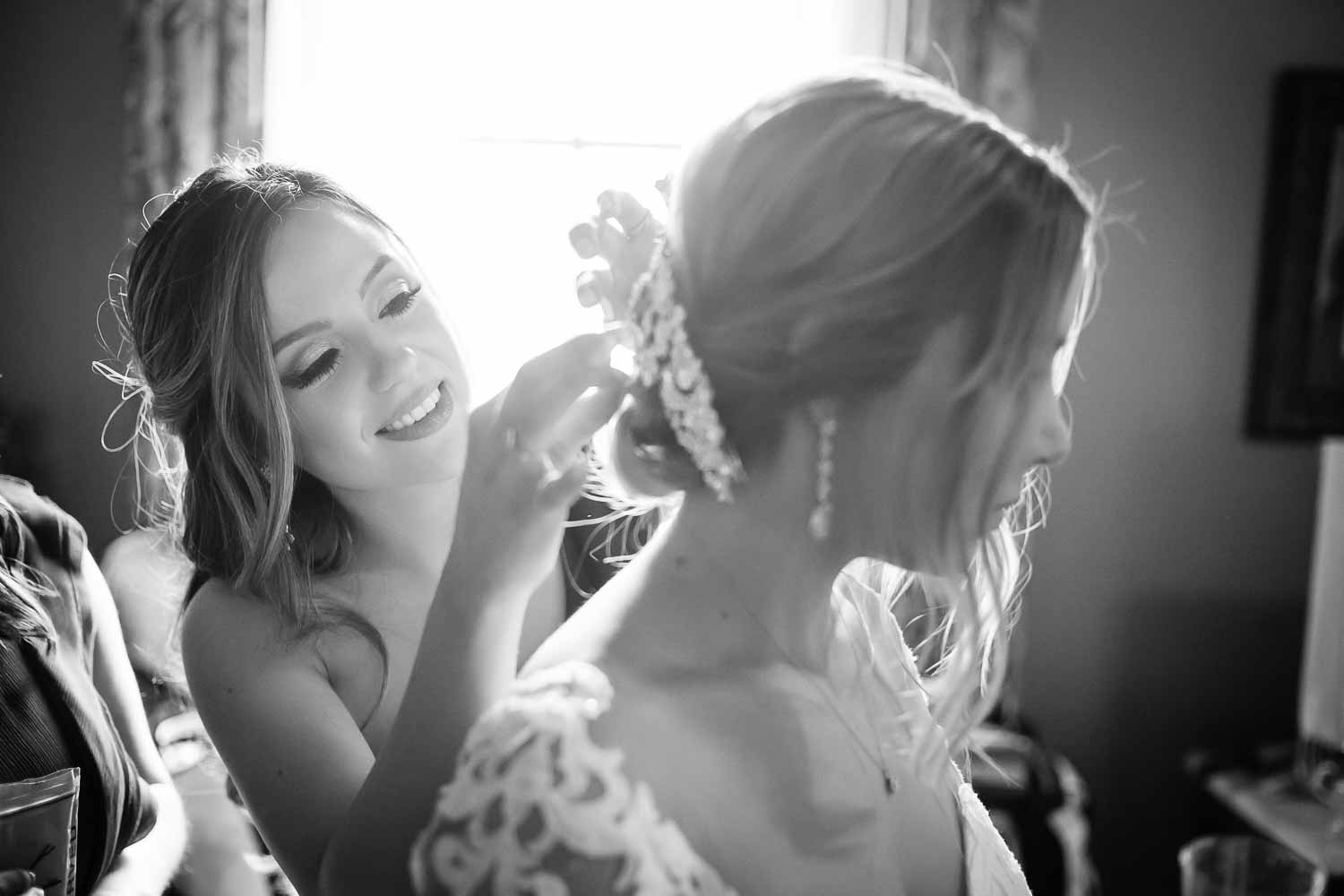 A Bridesmaid clips in a veil on the brides head at Menger Hotel Wedding Ceremony San Antonio Reception Grand BallroomSan Antonio -Leica photographer-Philip Thomas Photography